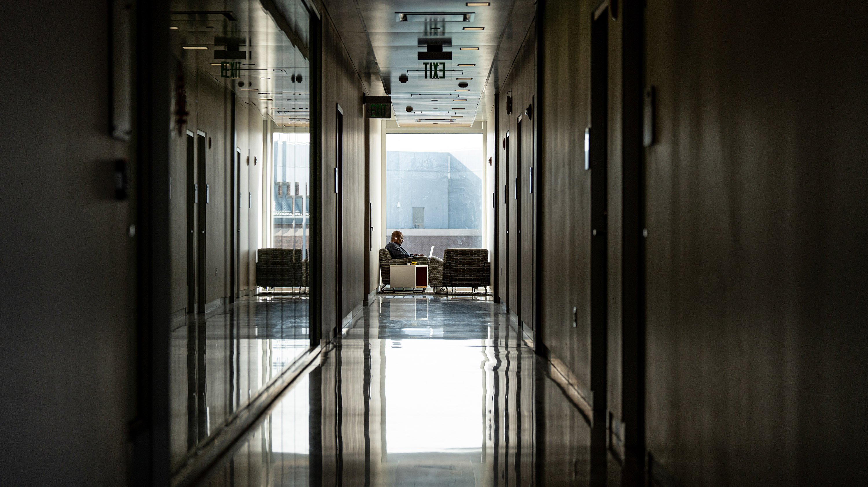 Student studying at the end of a long corridor