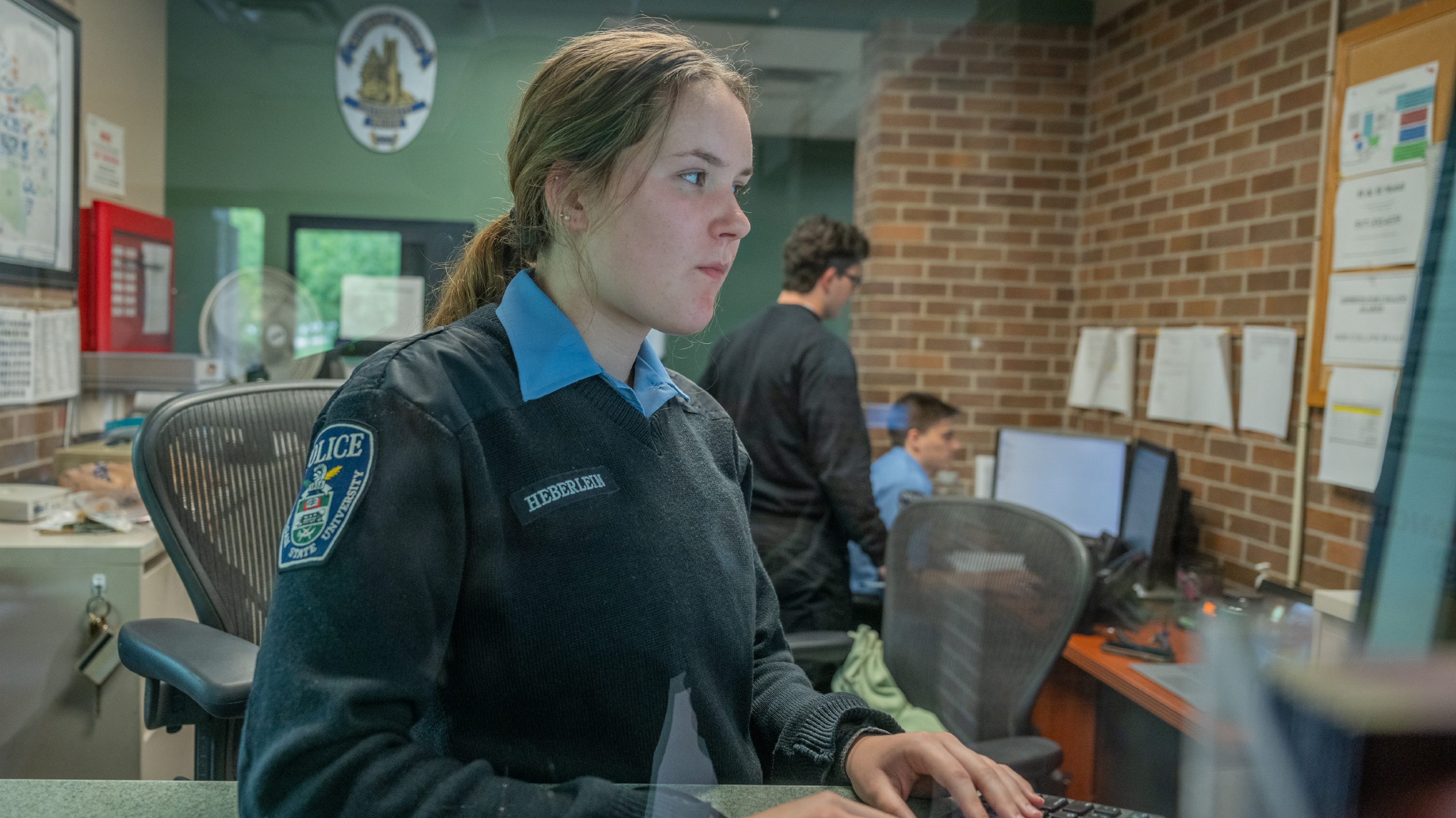 Mary Cate Heberlein smiles while sitting at a cadet desk.
