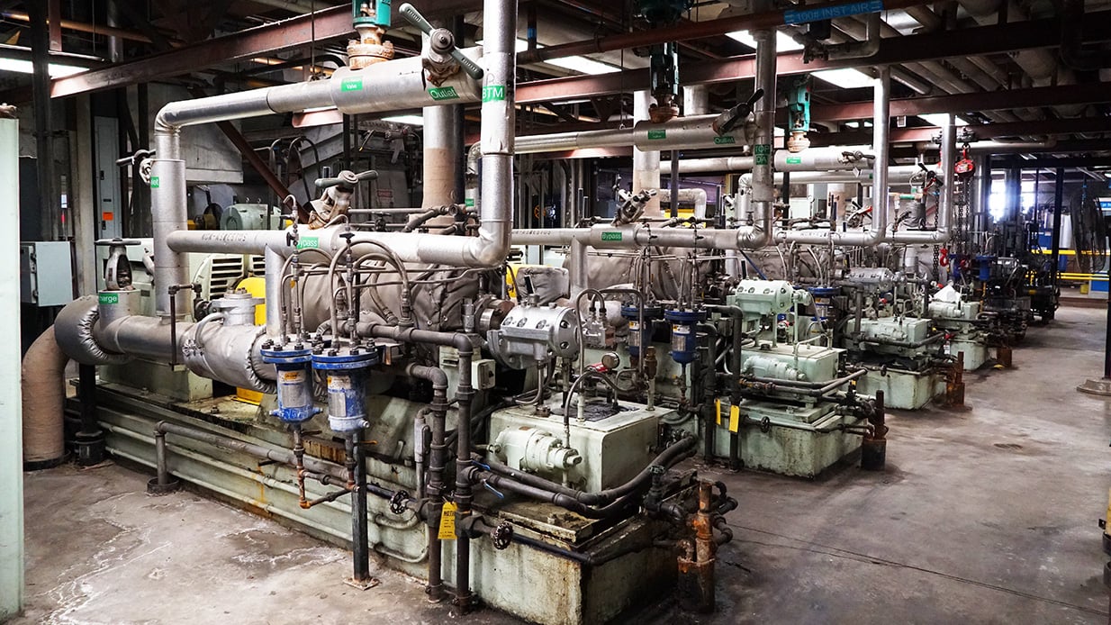 Four power generators and pipes in a large room.