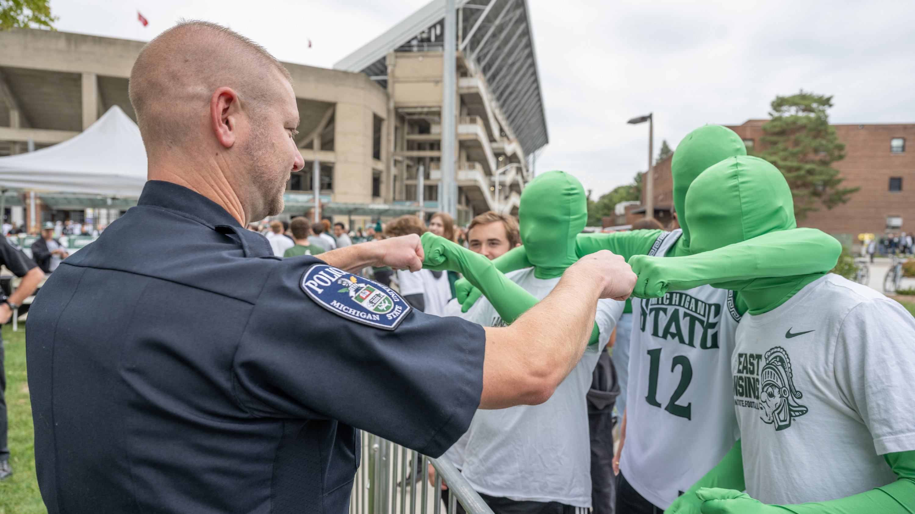 Lt. Brandon Murphy fist bumps fans as they enter Spartan Stadium.