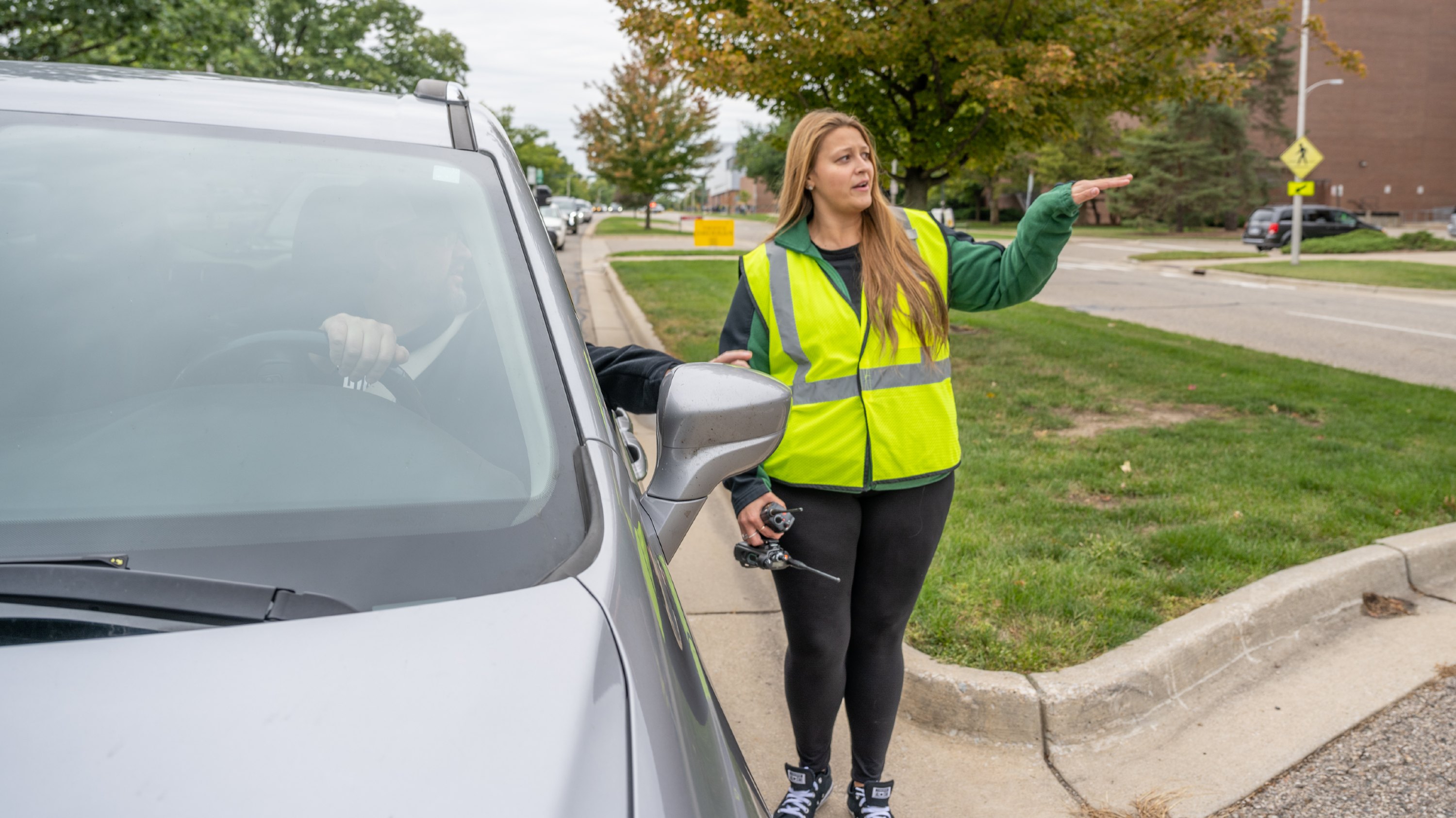 Nicole Ziegler directs a driver toward a parking garage.