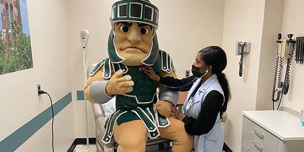 a nurse checks Sparty's heartbeat with a stethoscope