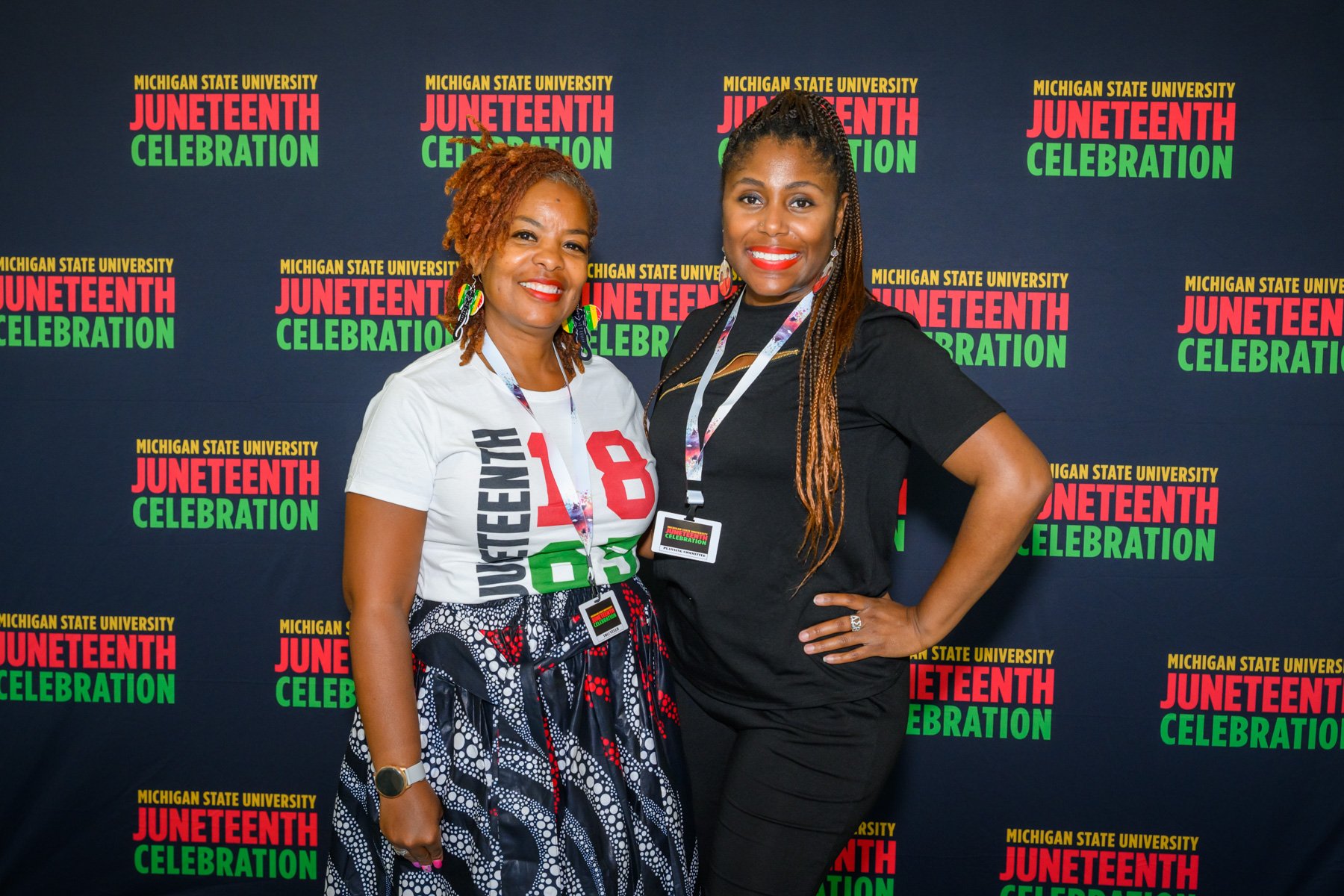 Carleen Gardner (left) and Shondra Marshall pose in front of Juneteenth backdrop.