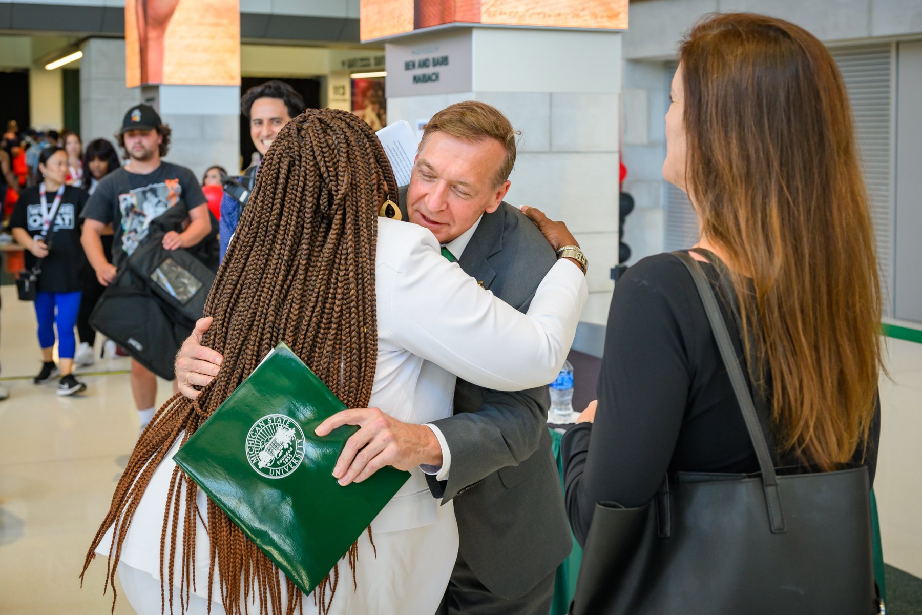 Samuel Stanley Jr. embraces Stephanie Anthony as she enters the Breslin Center.