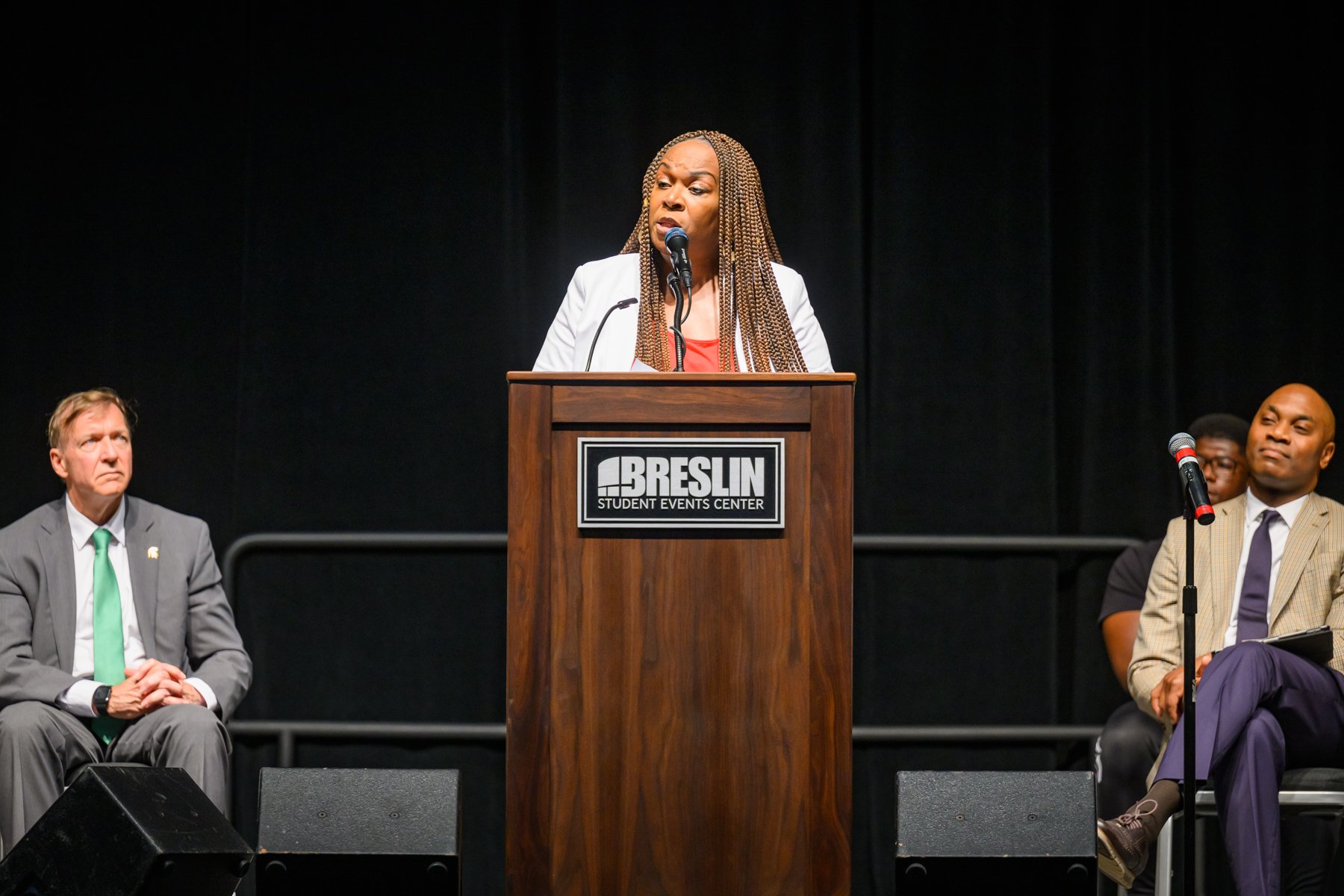 MSU Juneteenth speaker Stephanie Anthony standing at the lectern with Samuel Stanley Jr. and Jabbar Bennett in the background.