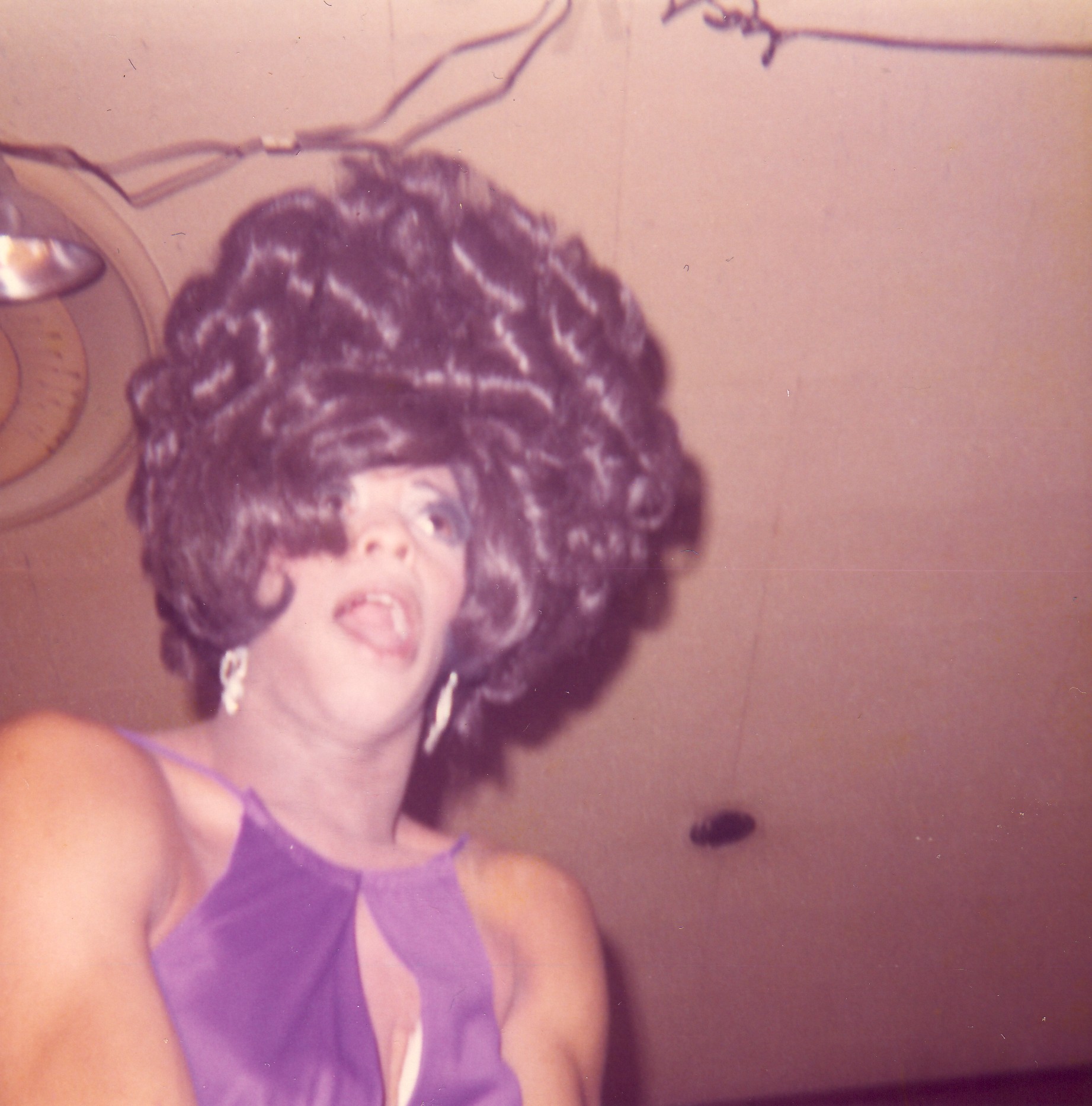 Drag queen performer at Joe Covello's bar in Lansing wearing a wig with earrings.