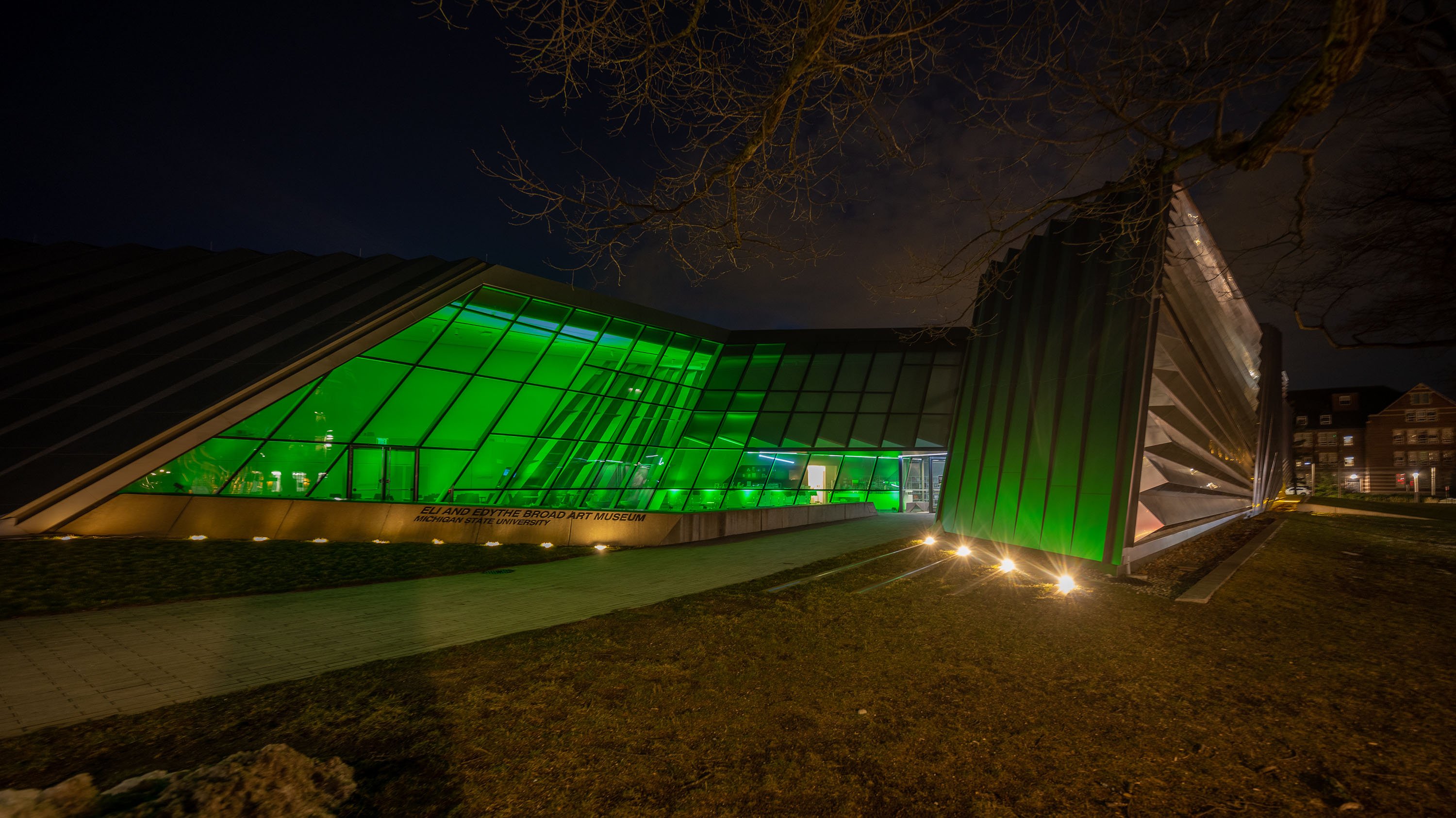 Broad Art Museum glowing with green interior lights at night