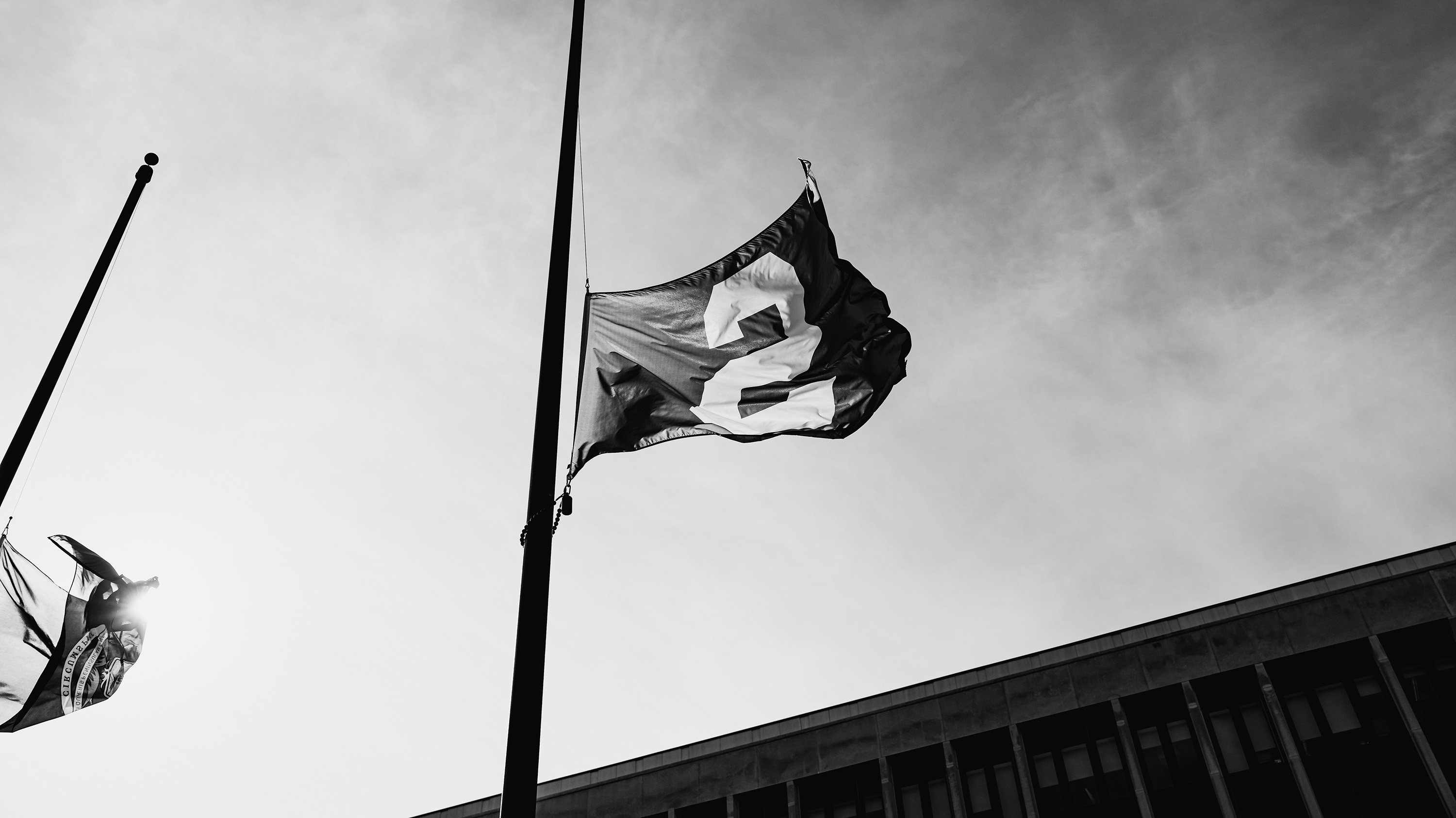 Black and white image of Spartan flag flown at half-mast