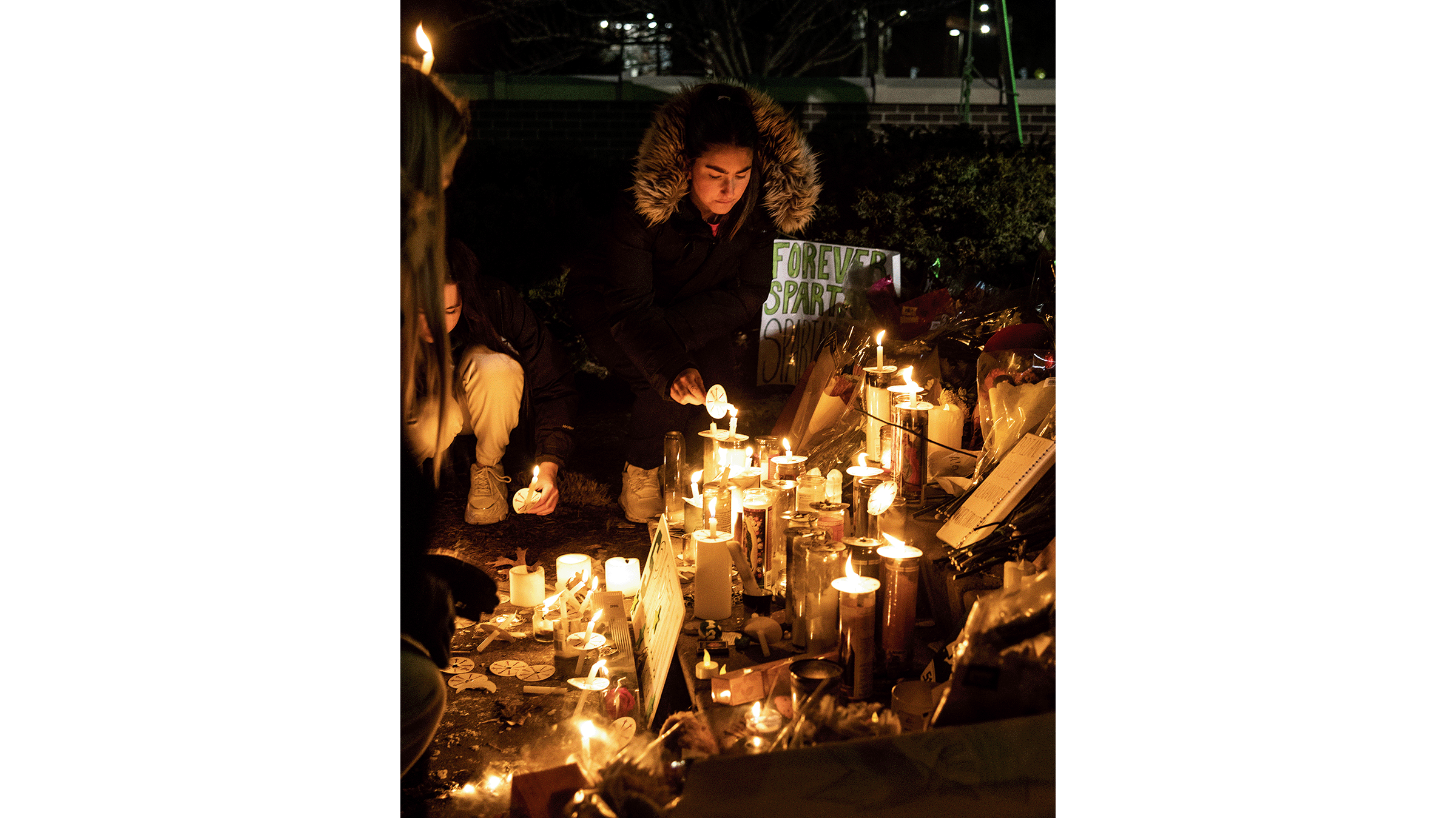 Students lighting candles for vigil