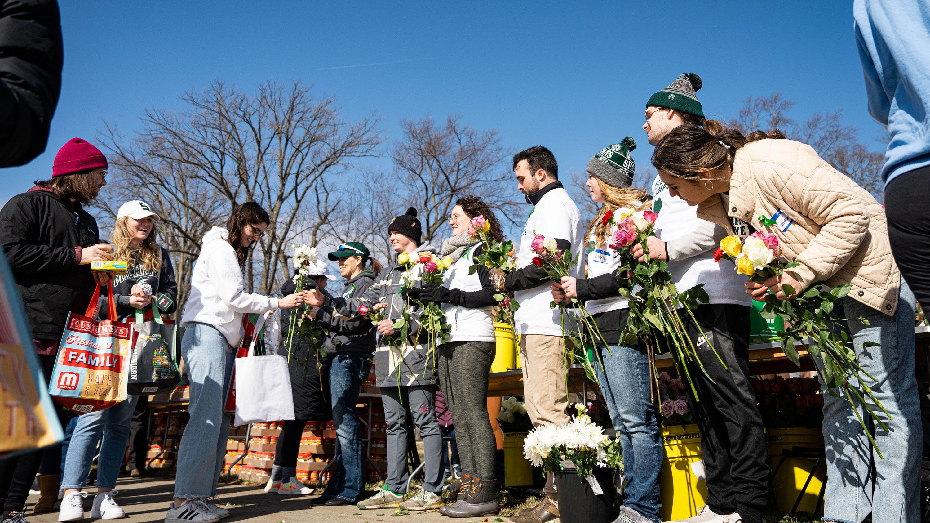 Volunteers passing out flowers to students at Spartan Sunday
