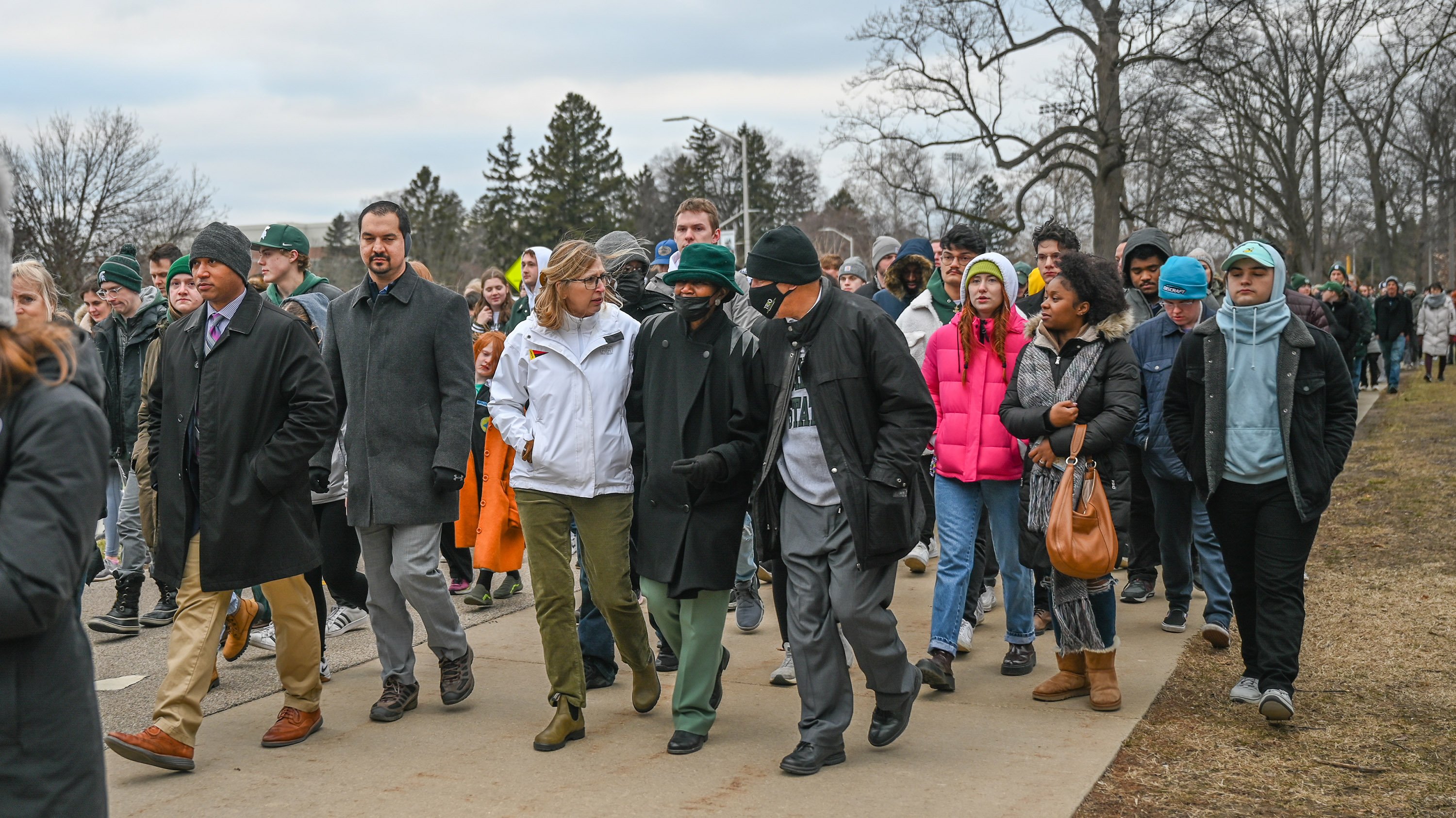 Interim President Woodruff walking with a group of people from the Spartan statue to the vigil