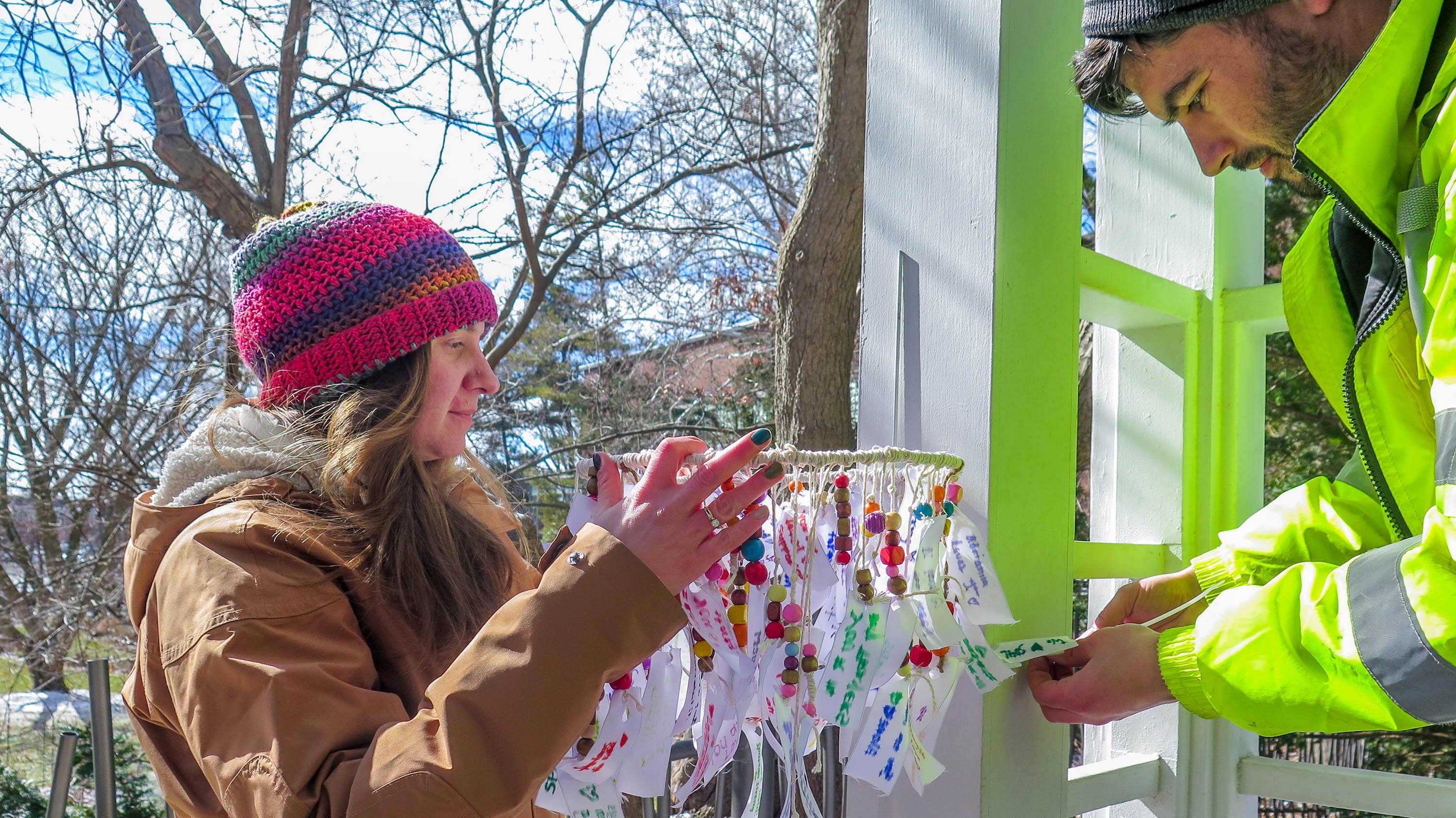 Beal staff hang colorful mobiles of fabric strips and beads