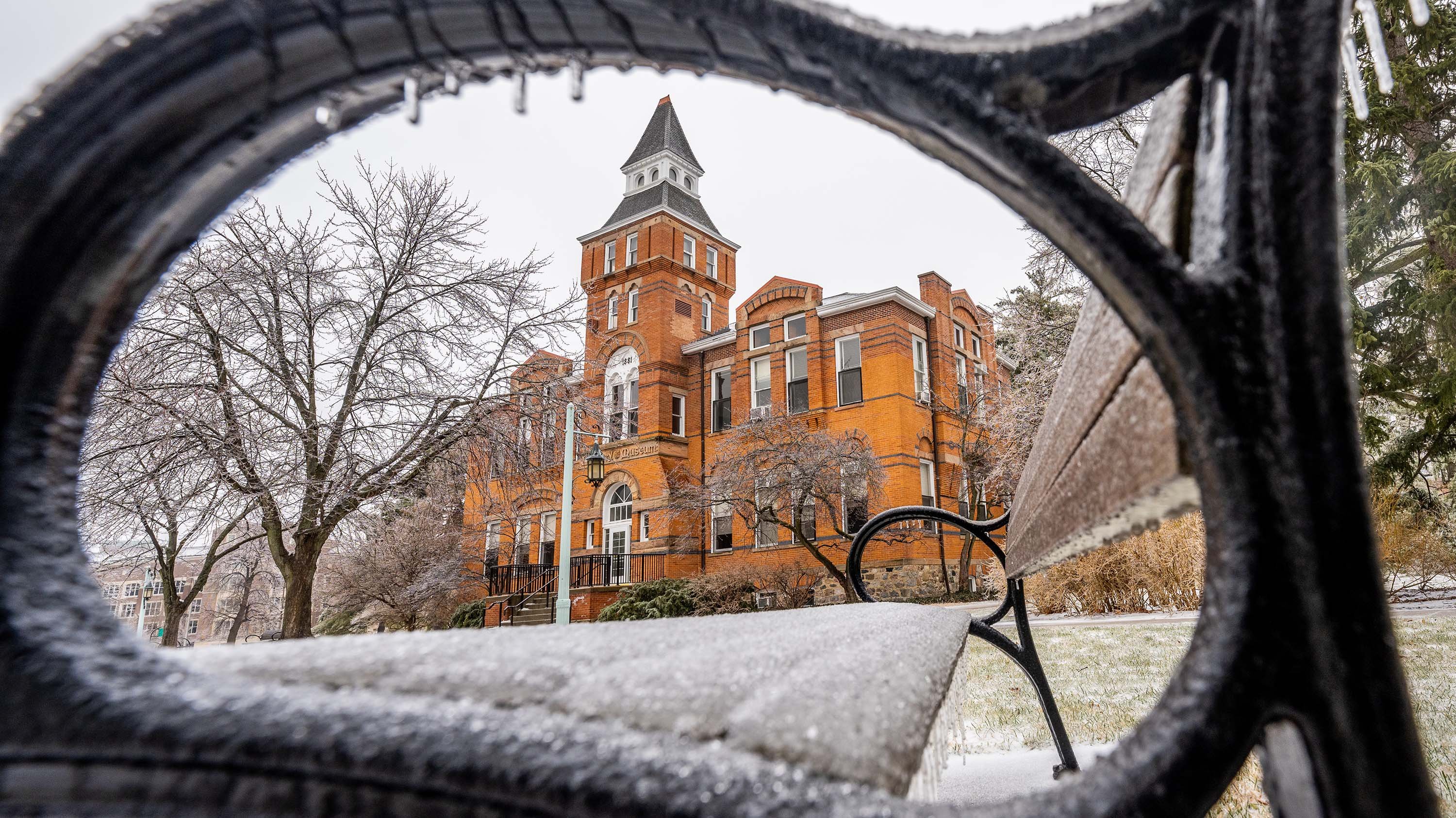 Linton hall framed by the armrest of a bench