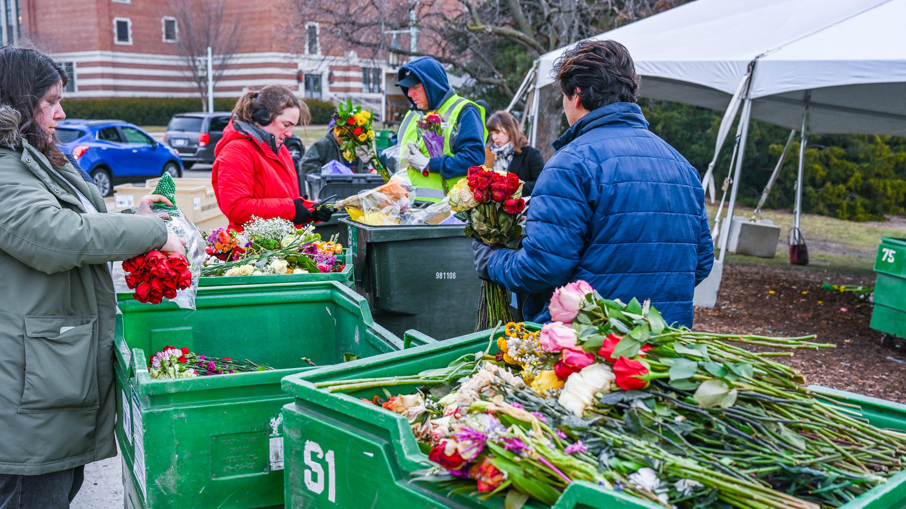 People recycling flowers from MSU memorial spaces