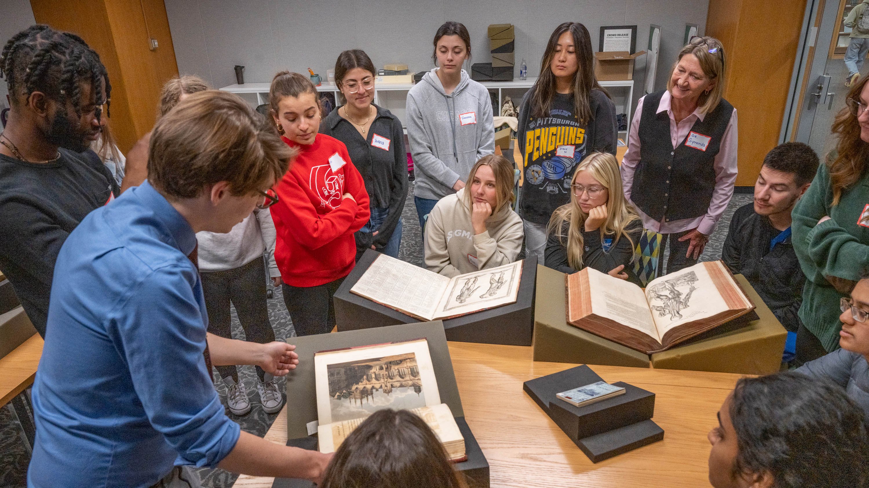 Tad Boehmer showing rare books to a group of students