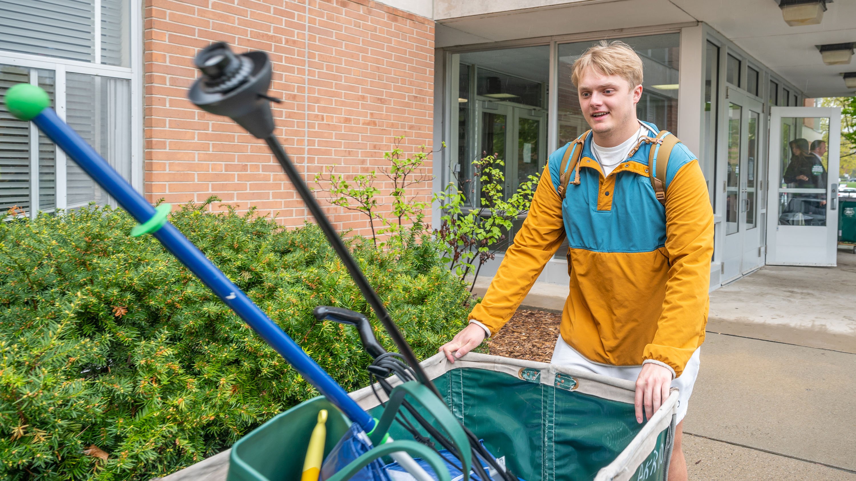Student moving out of Akers with laundry cart