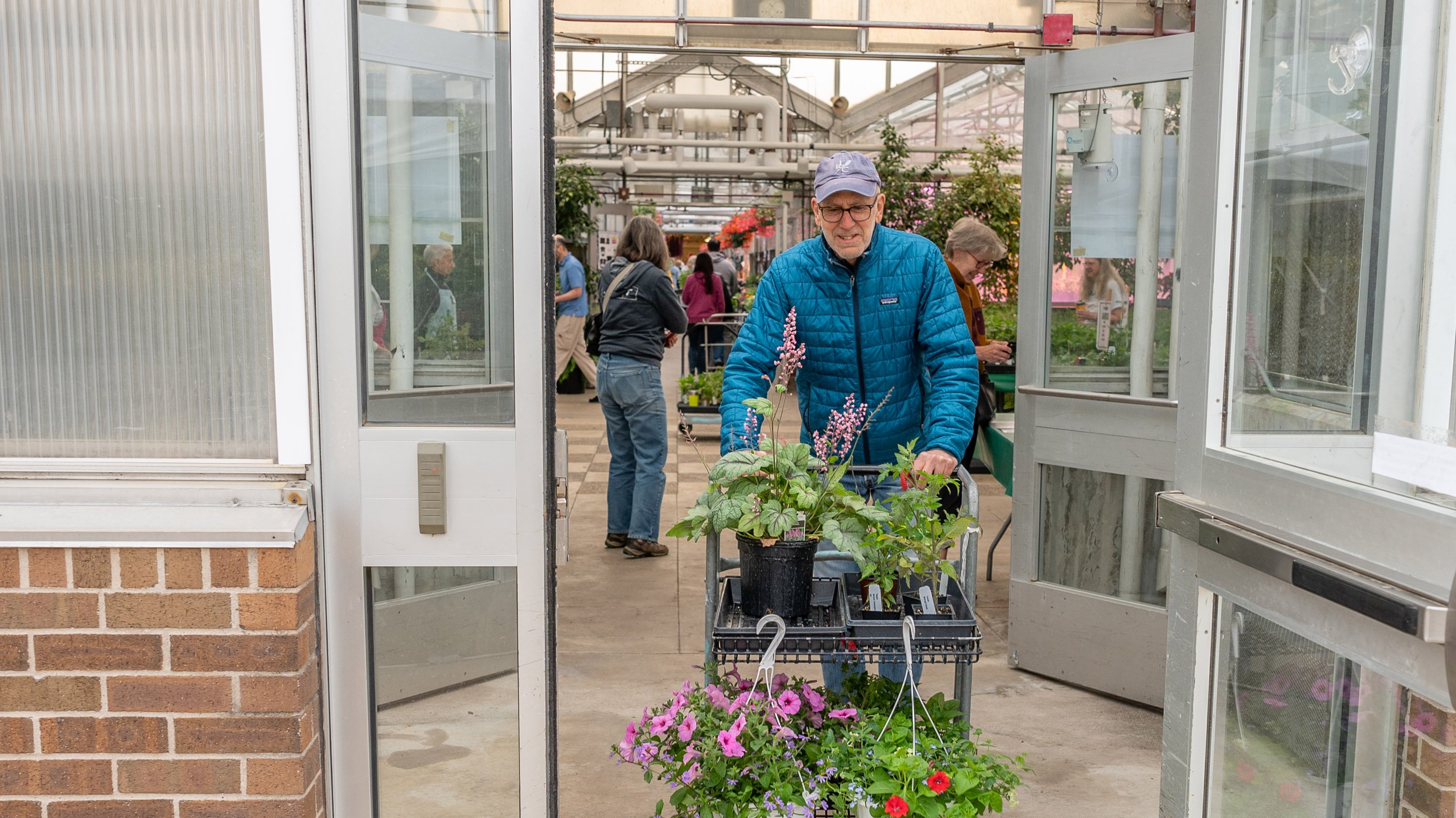 Man with rolling cart of plants