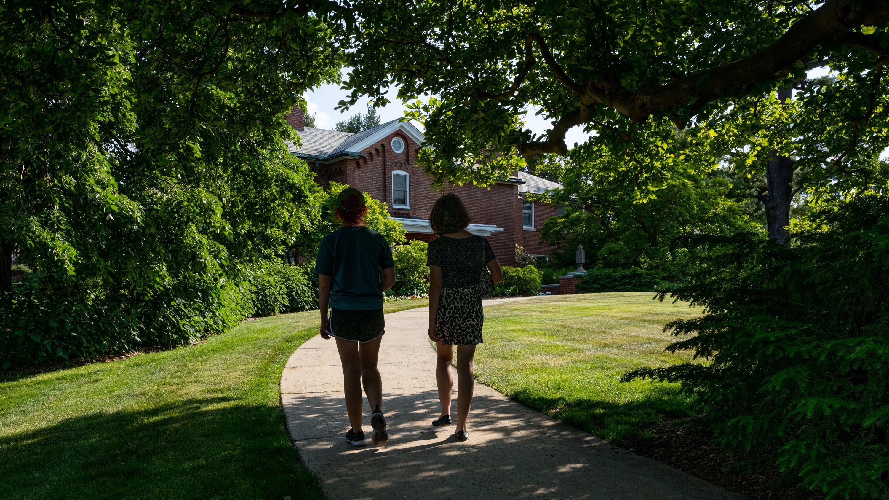 Two silhouetted figures walking in front of Cowles House