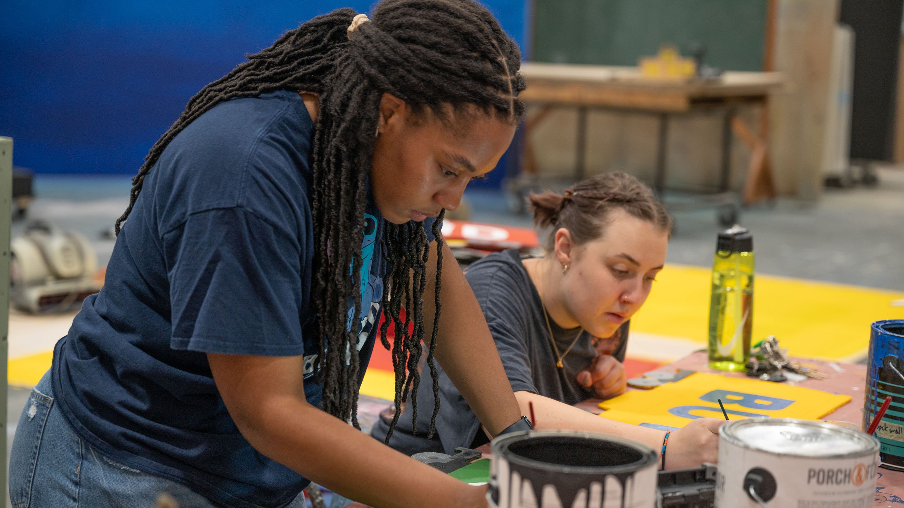 Two students painting props