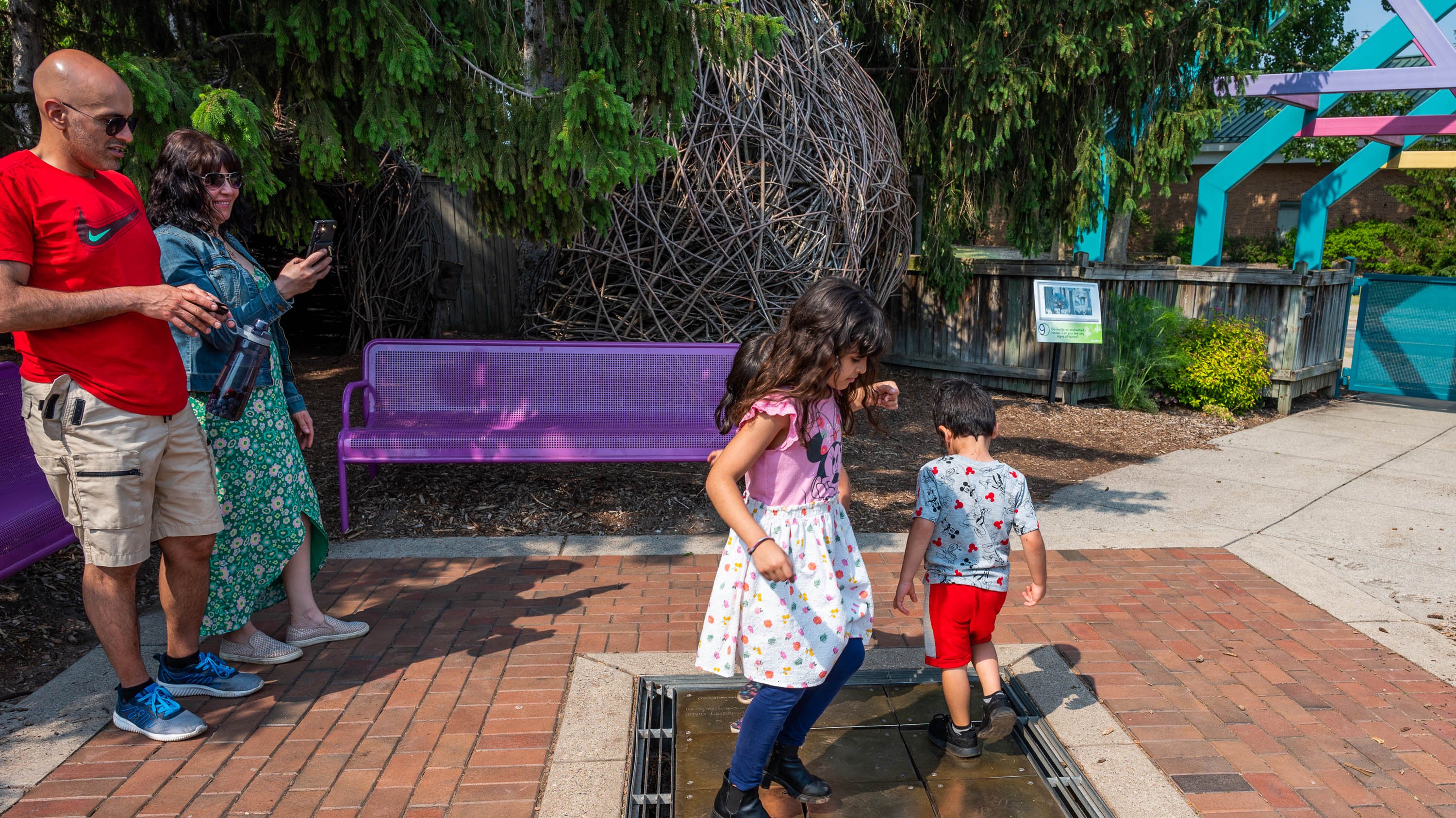 Visitors in the Michigan 4-H Children's Gardens playing on musical tiles