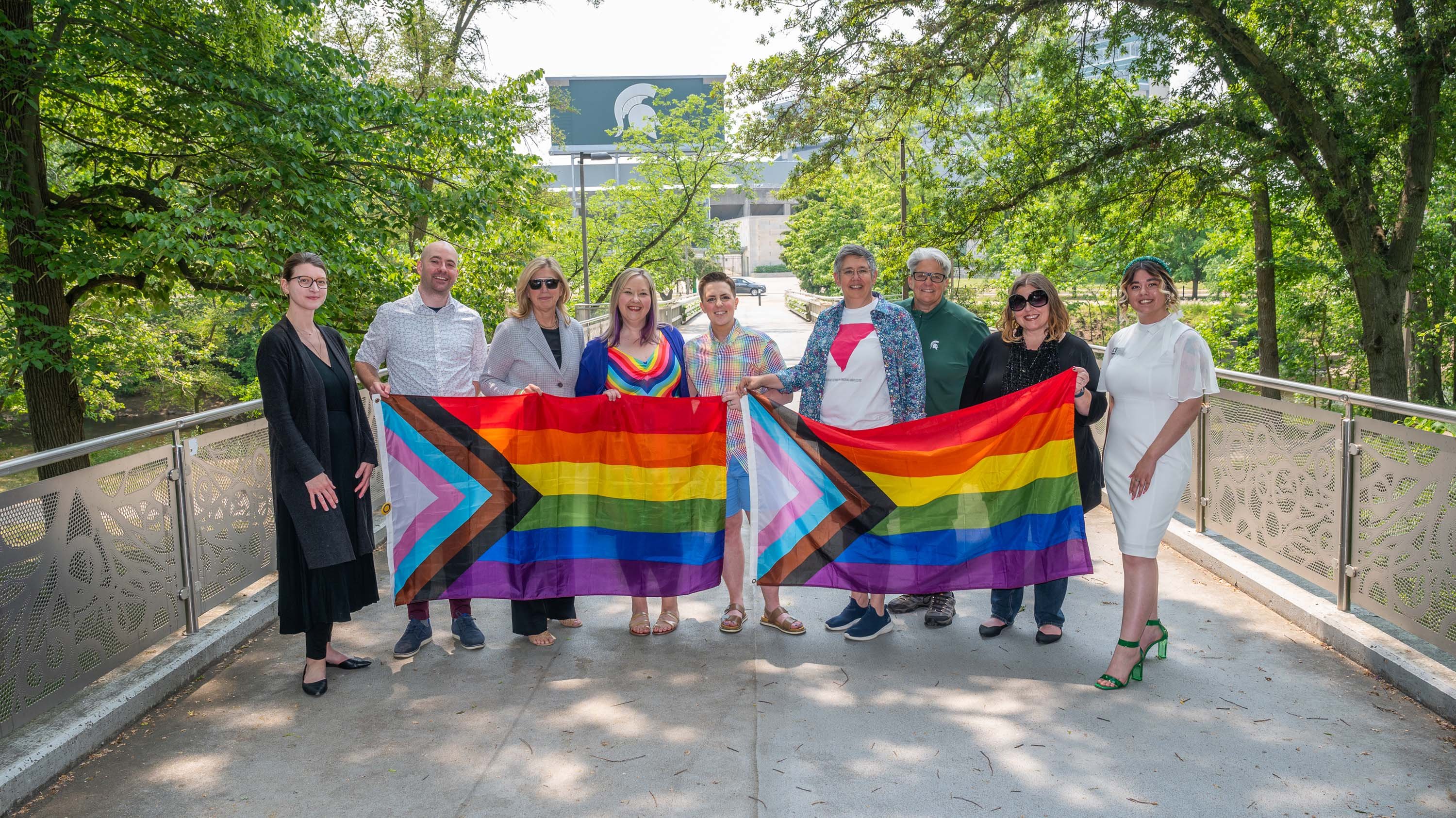 Interim president woodruff holding pride flags with Employee Pride and Inclusion Coalition members