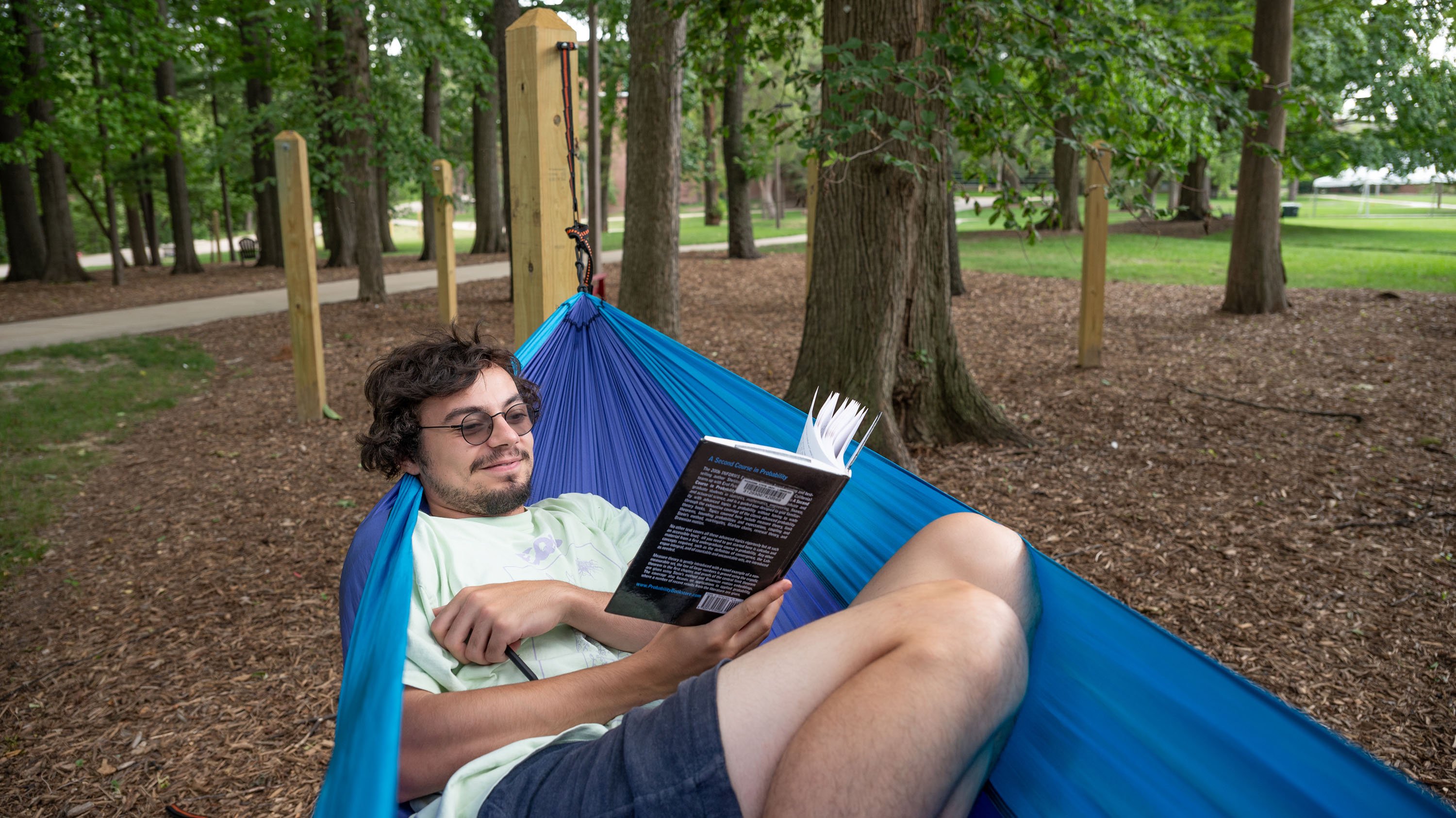 Man reading book in a hammock