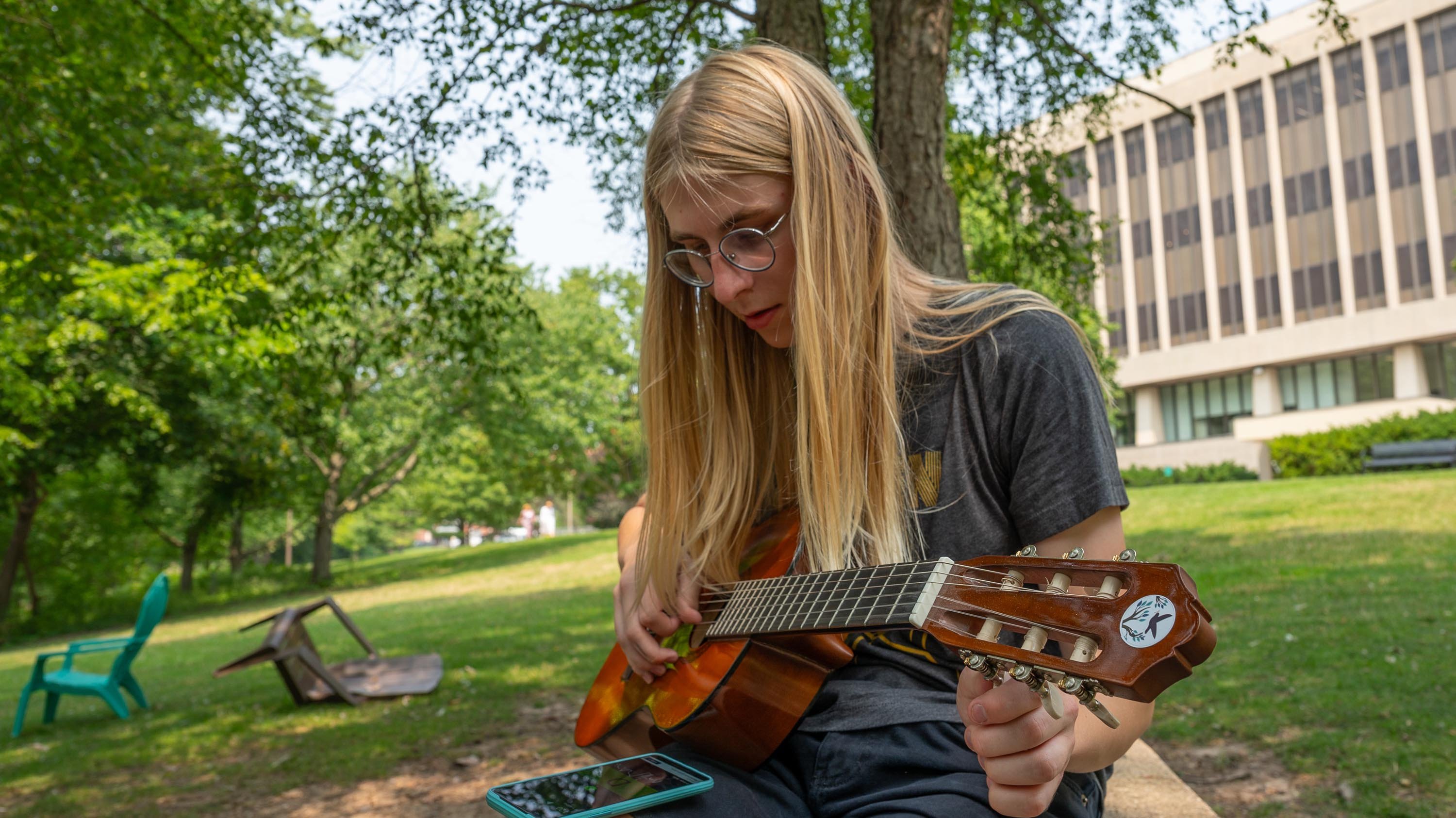 Alia Valentine playing guitar on campus