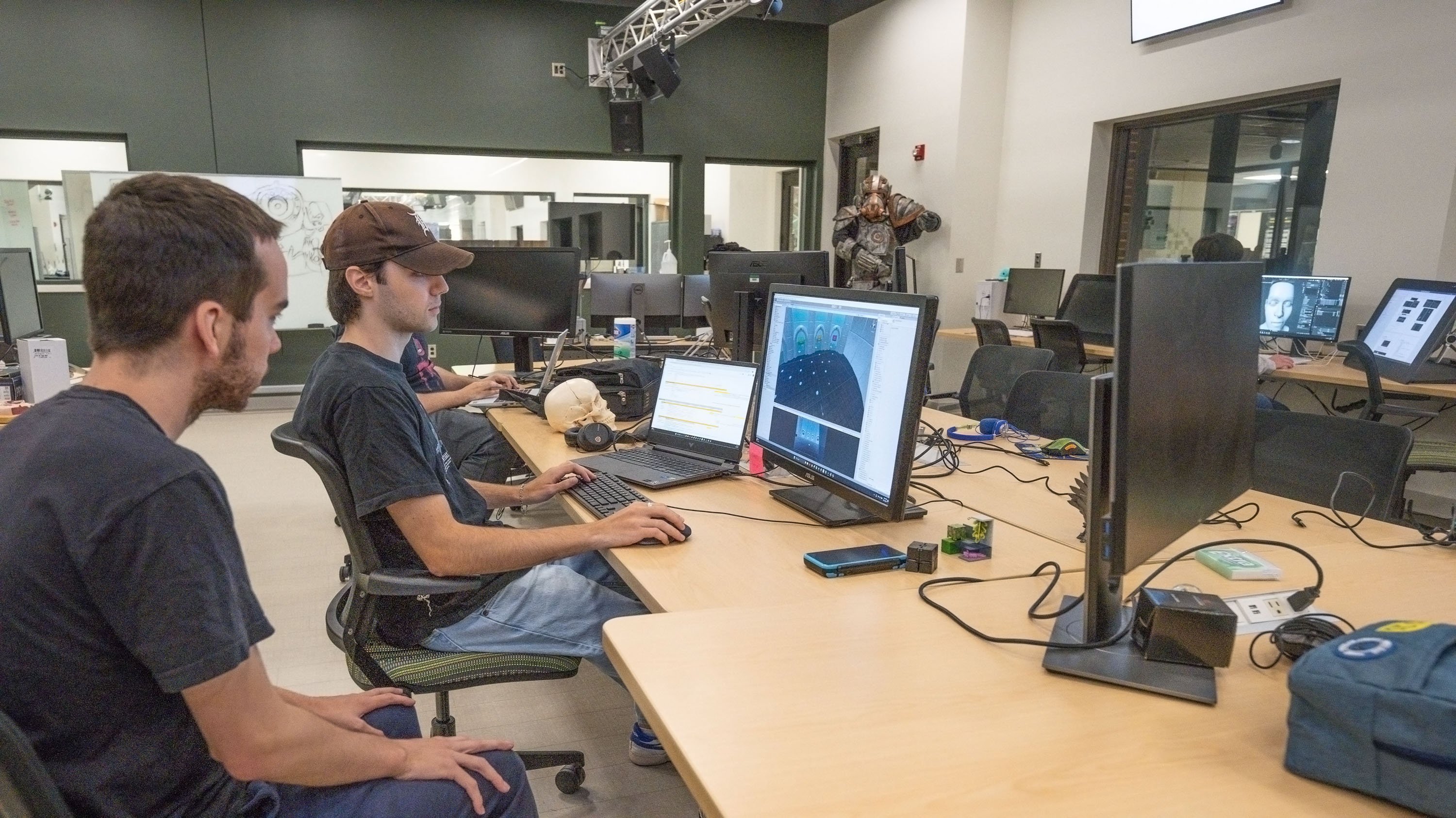 Two people sitting in computer lab working on video game