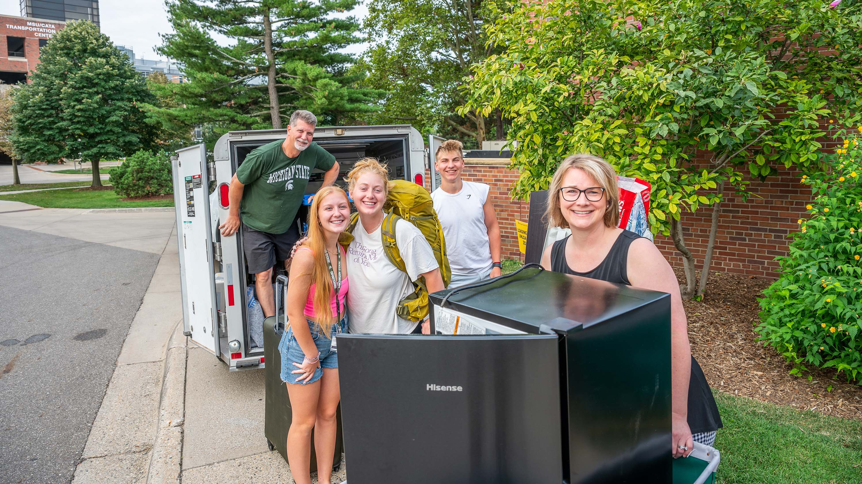 Family unloading storage pod during move-in