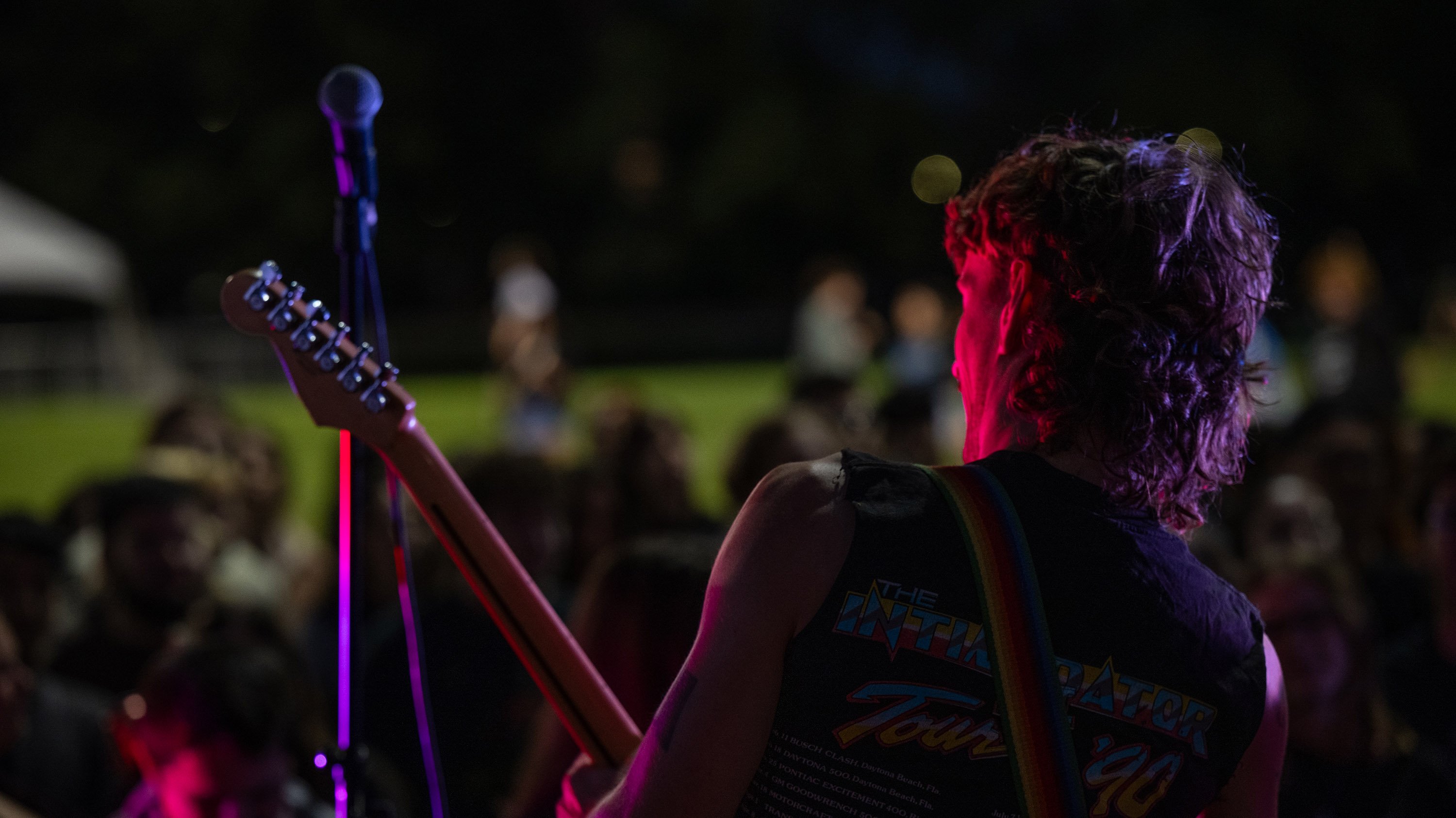 Student musician performing on stage with colored lights