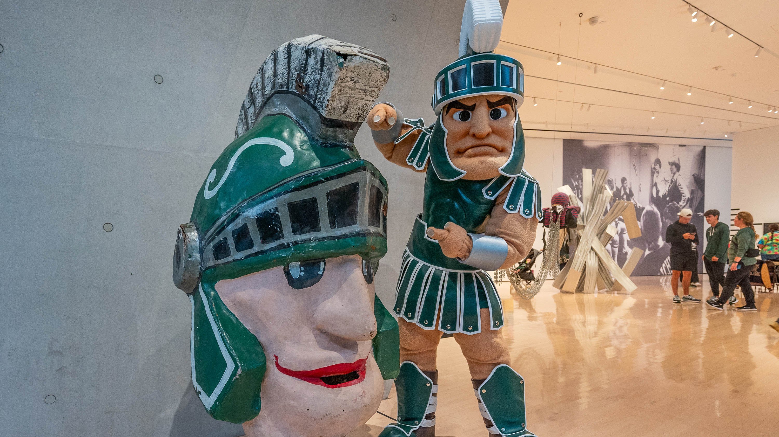 Sparty posing with vintage paper mascot head at Broad Art Museum