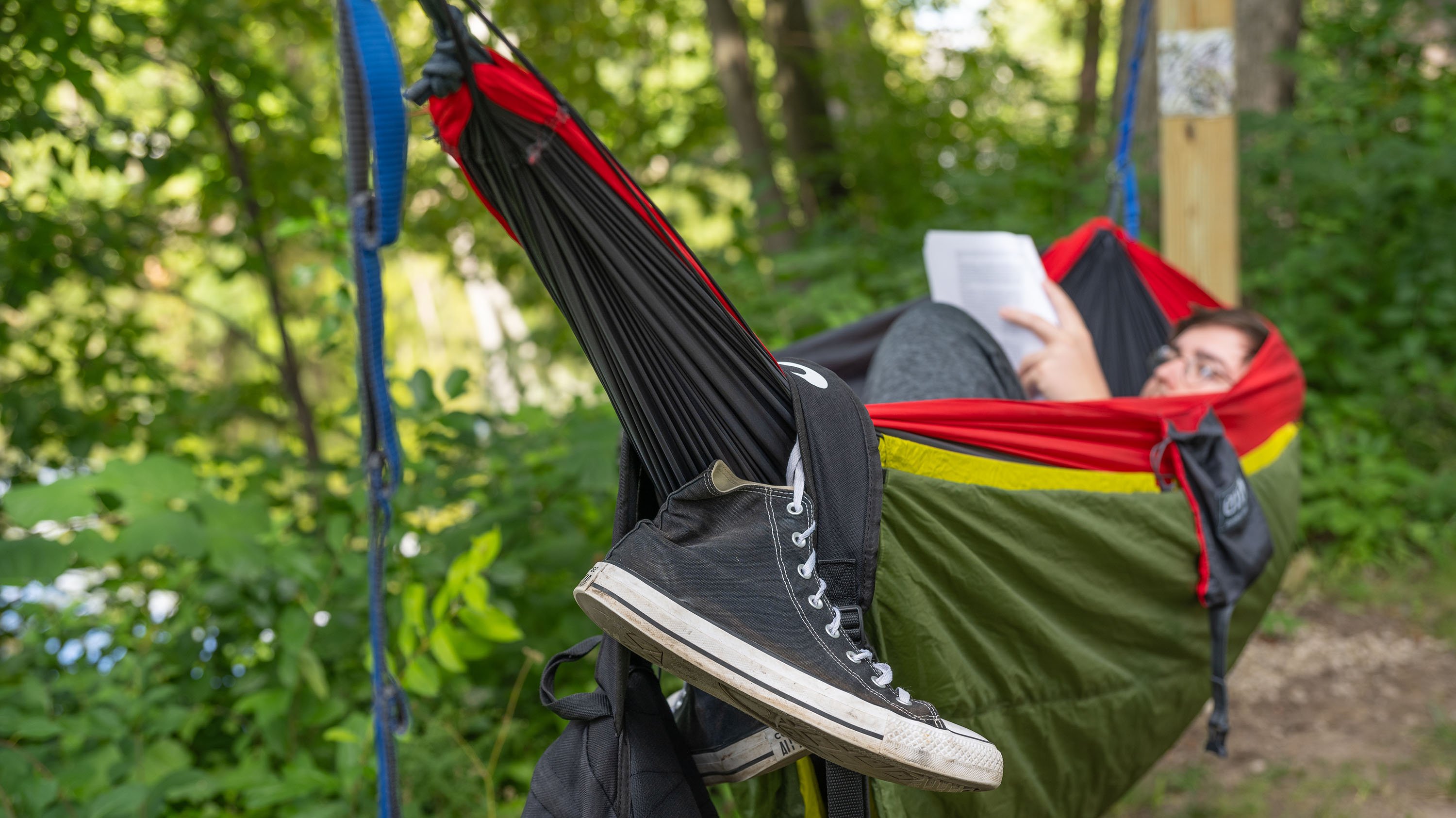 Student sitting in hammock reading book