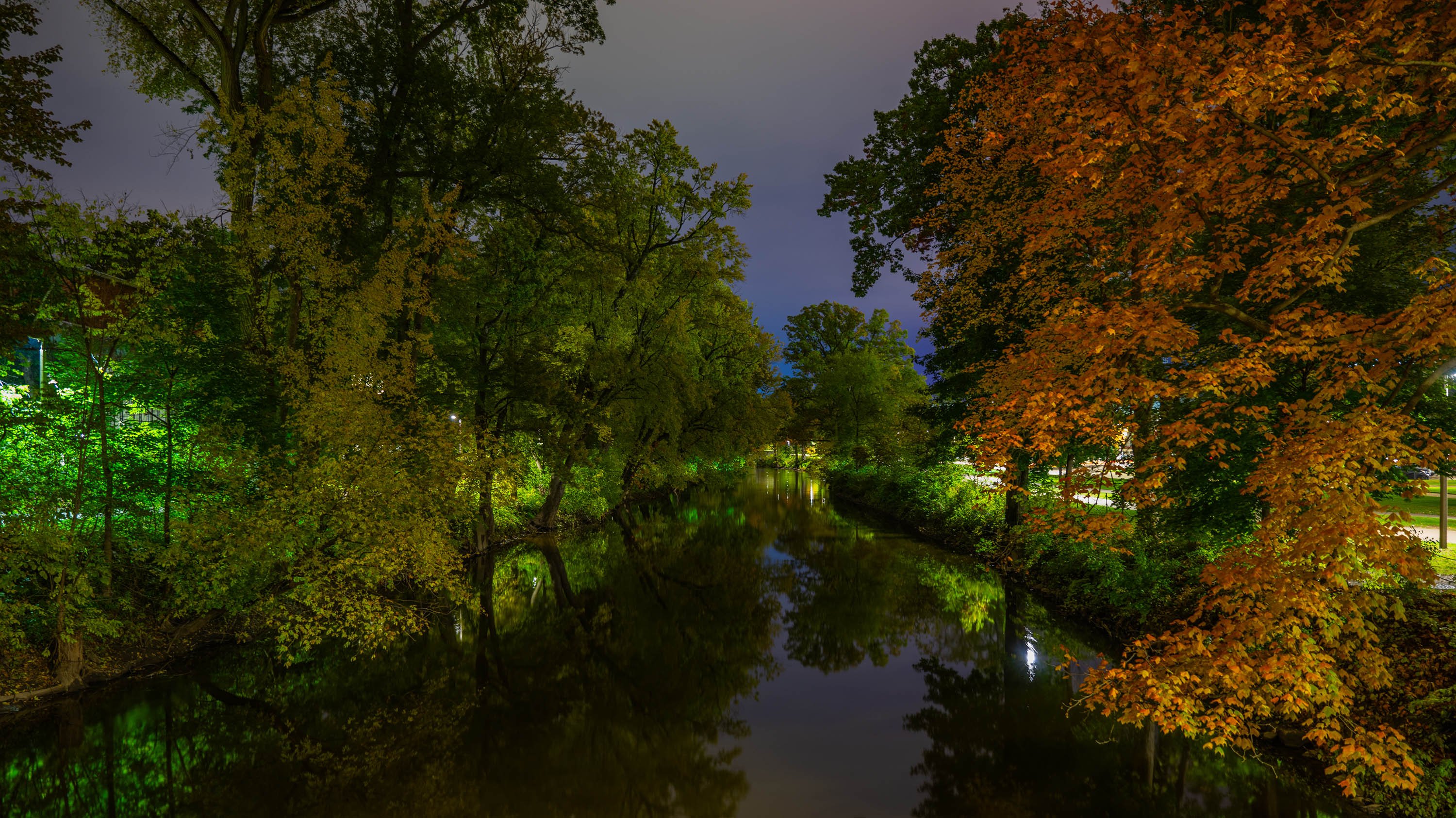 Red Cedar river at night with green lights glowing on sides