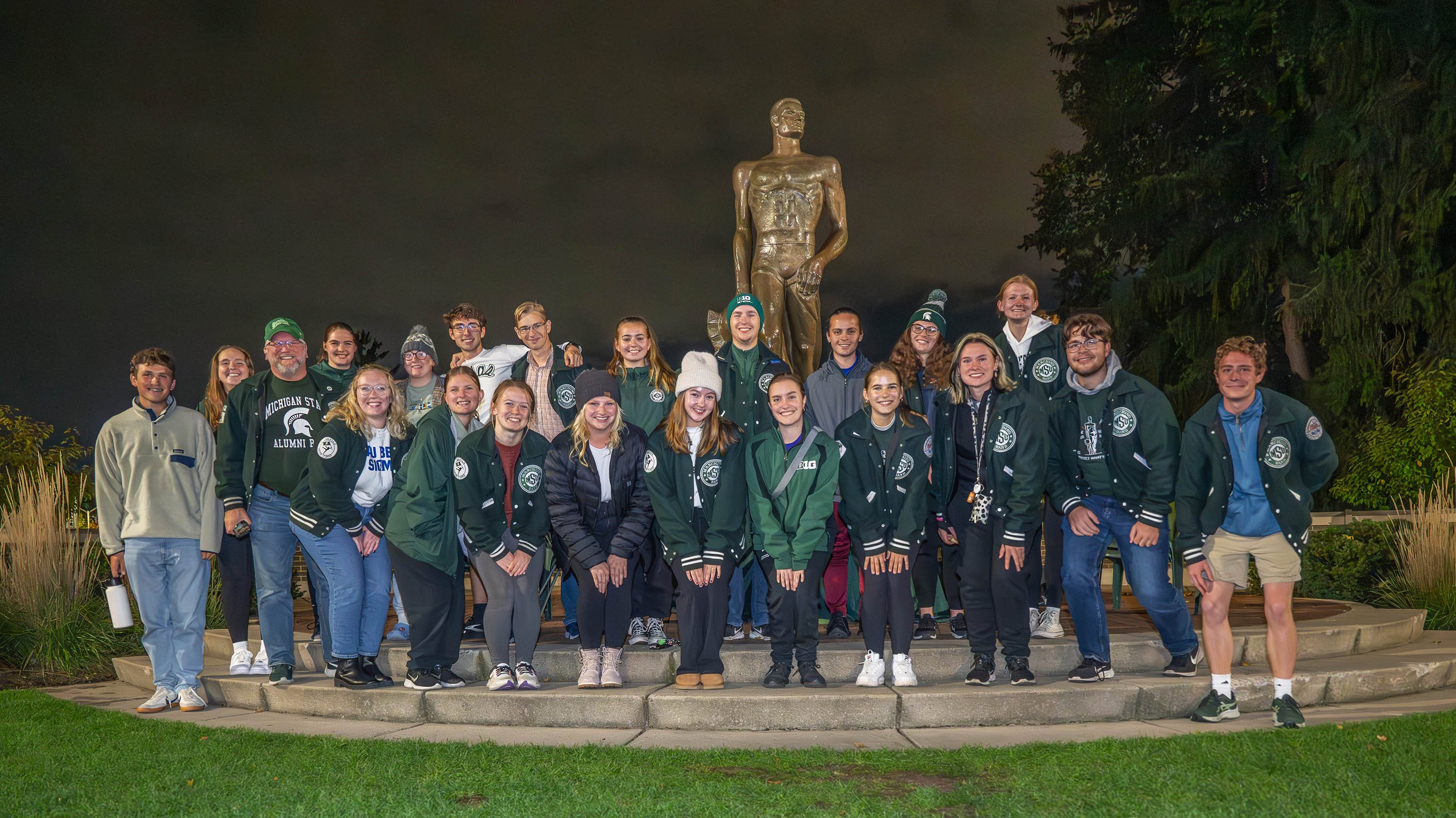 Members of Spartan Marching Band and Sparty watch posing in front of The Spartan