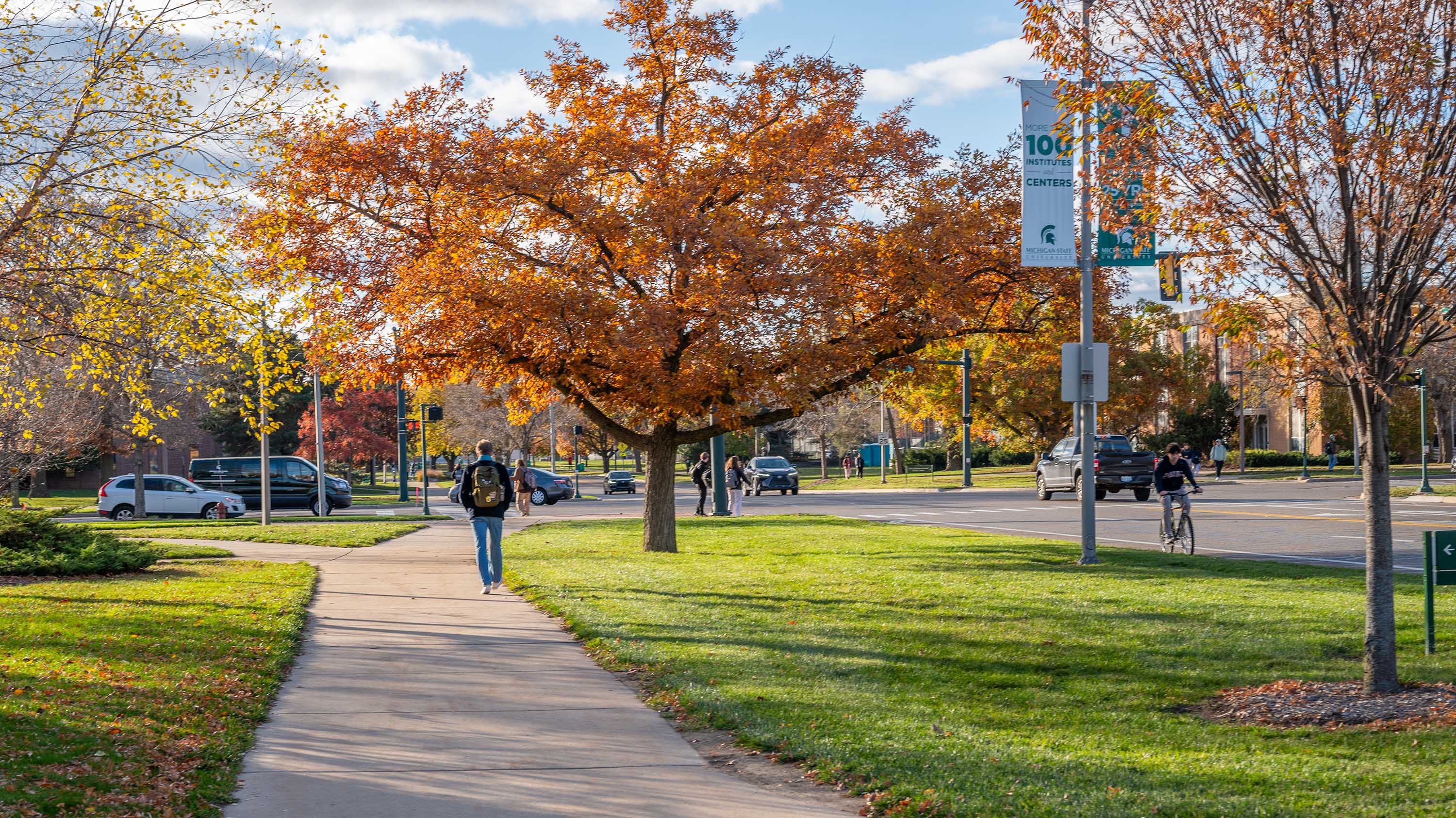 Student walking along West Wilson road in autumn