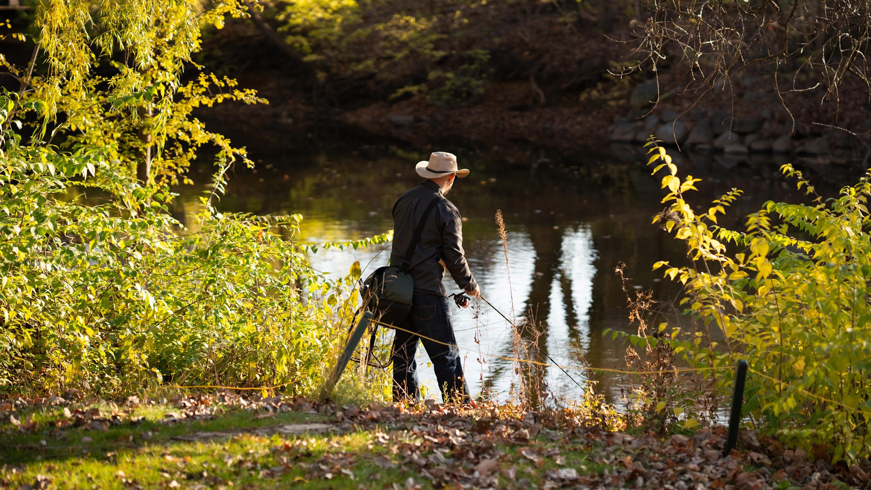 Person fishing on the banks of the Red Cedar river