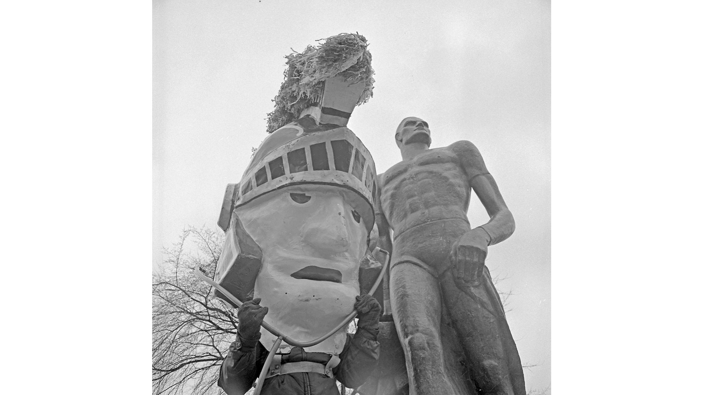 Health day promotion with the Sparty Statue and the Sparty paper mache head mascot standing next to each other from 1974. The Sparty mascot is wearing a large stethoscope.