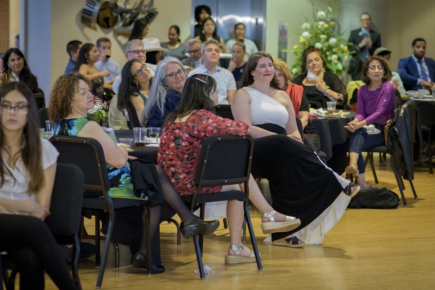 CLS Director M. Isabel Ayala (in white and black) sits with the crowd at the 25th anniversary celebration of the Chicano/Latino studies program at MSU. Photo by Jackie Belden Hawthorne