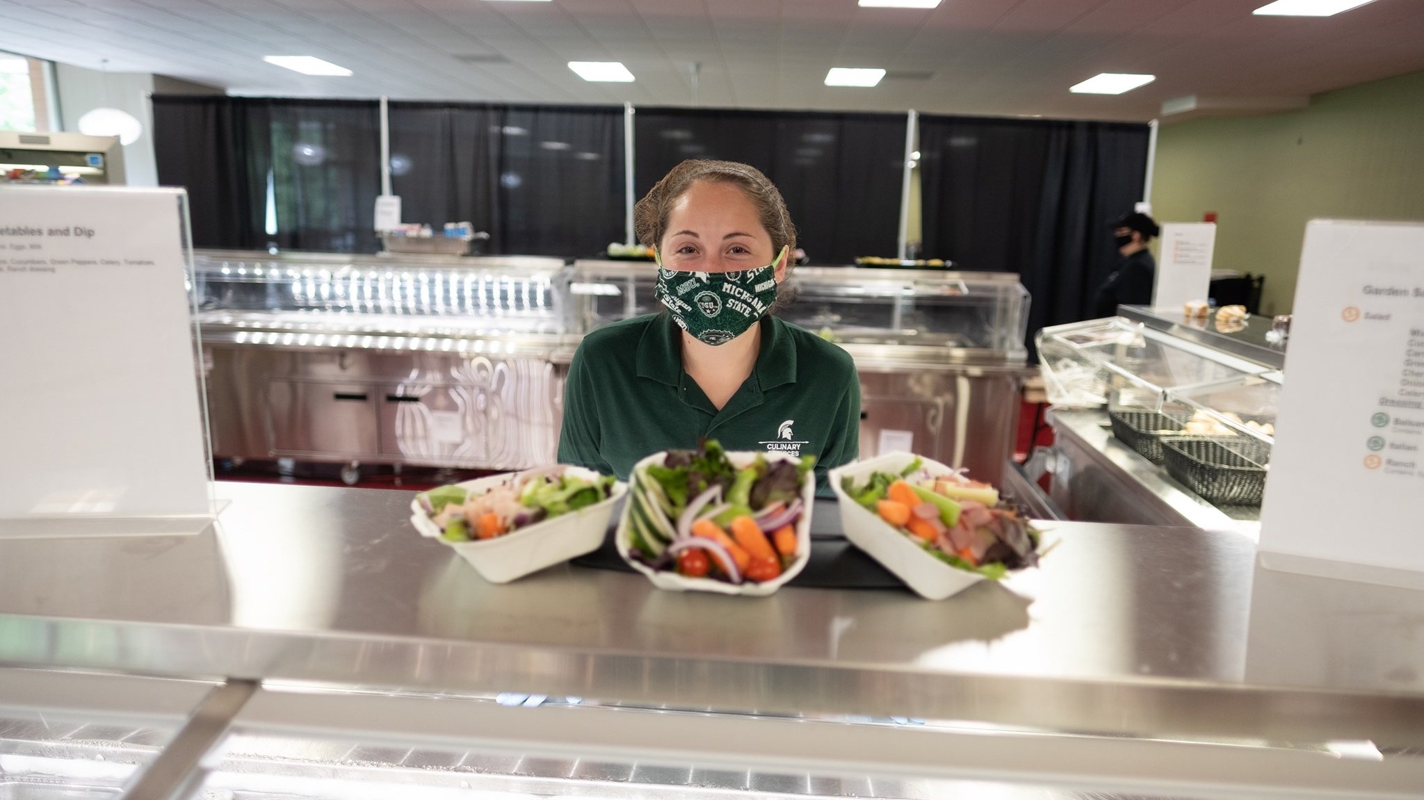 Student employee with to-go vegetable and dip plates at Holmes Dining