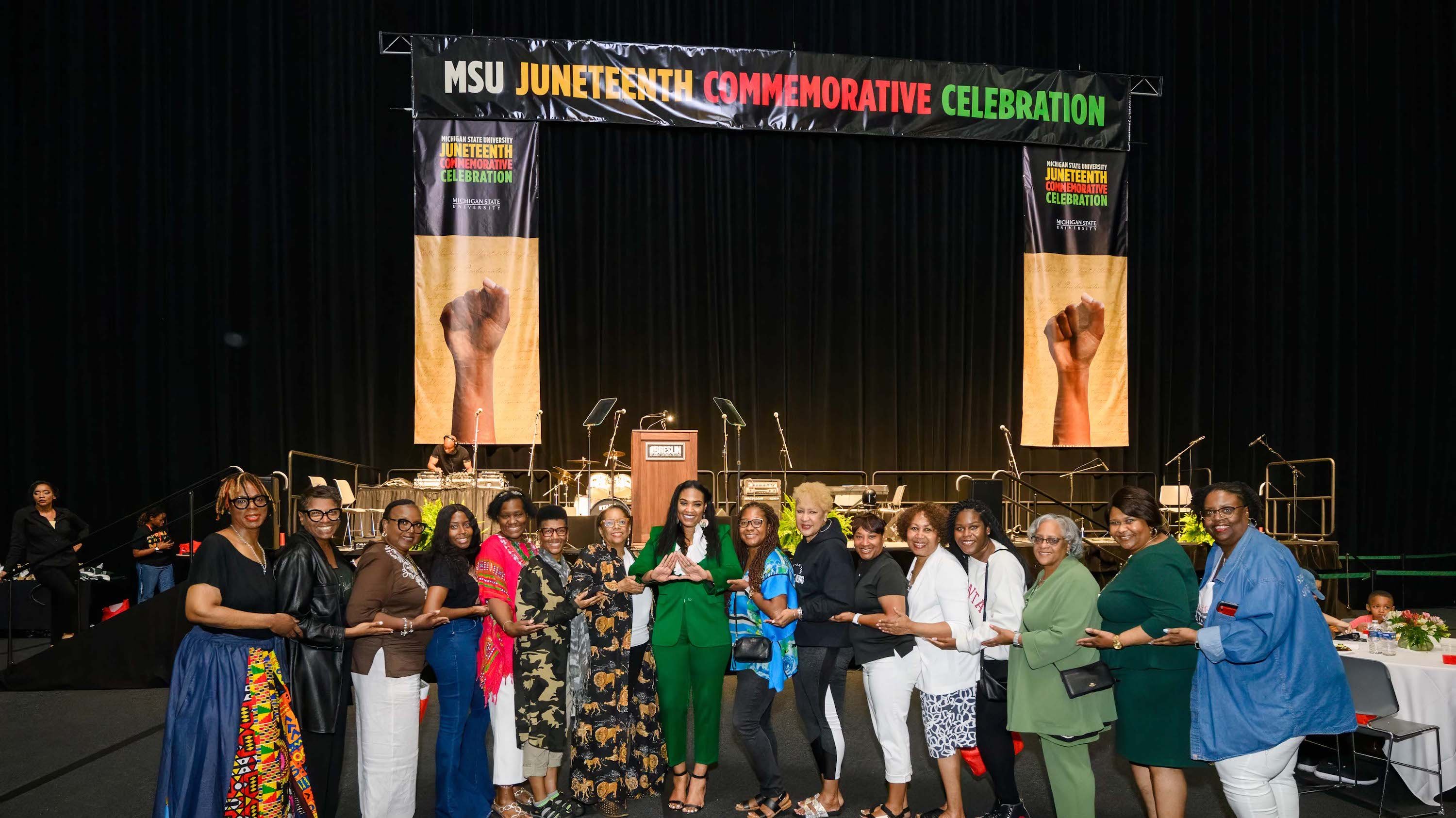 MSU leaders, administrators and attendees gather for a photograph in front of the stage at the MSU Juneteenth Celebration