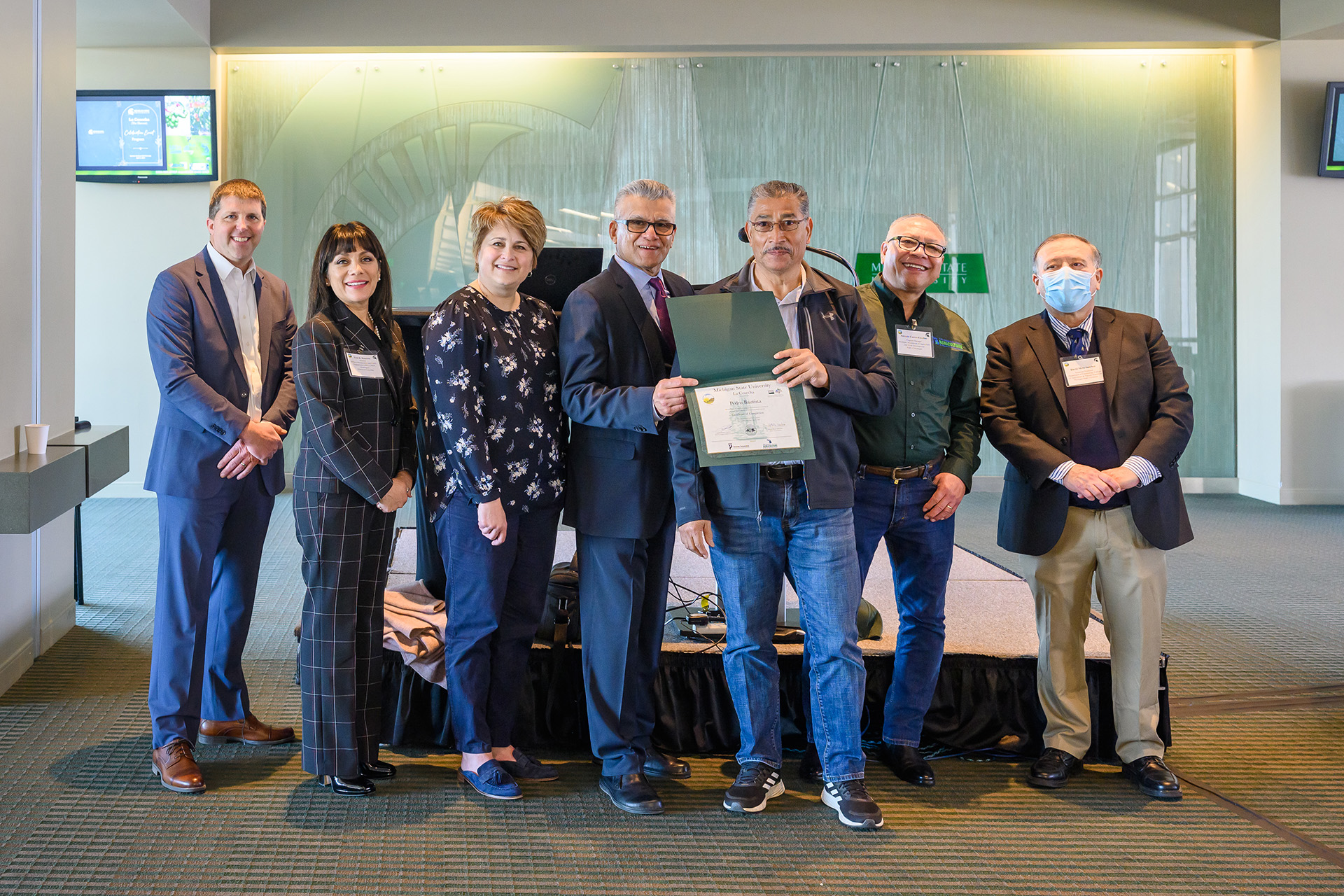 Event speakers and organizers pose with honored farmer