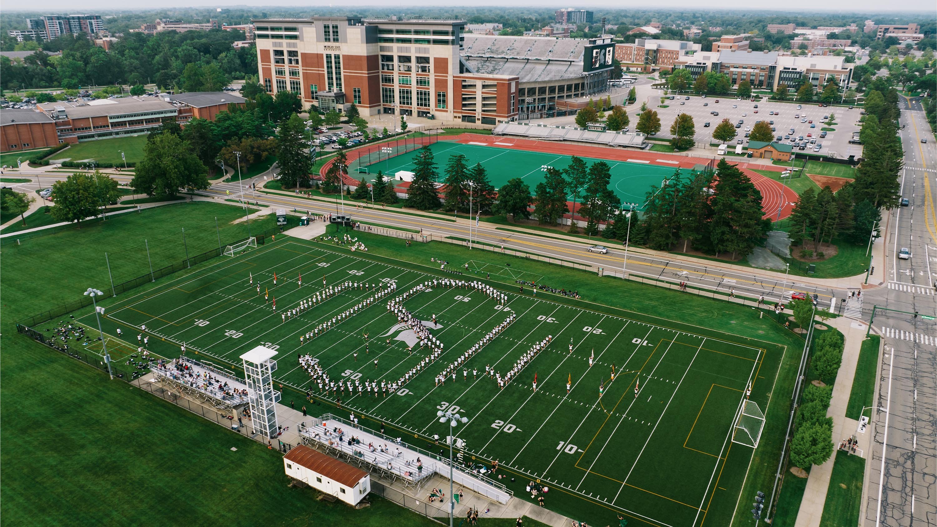 Munn Intramural Field with Spartan Marching Band practicing on it, forming the initials MSU