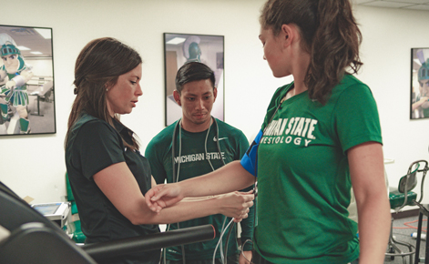 Currie (left) works with students in her Exercise and Cardiovascular Health Outcomes lab in the Department of Kinesiology (2019).