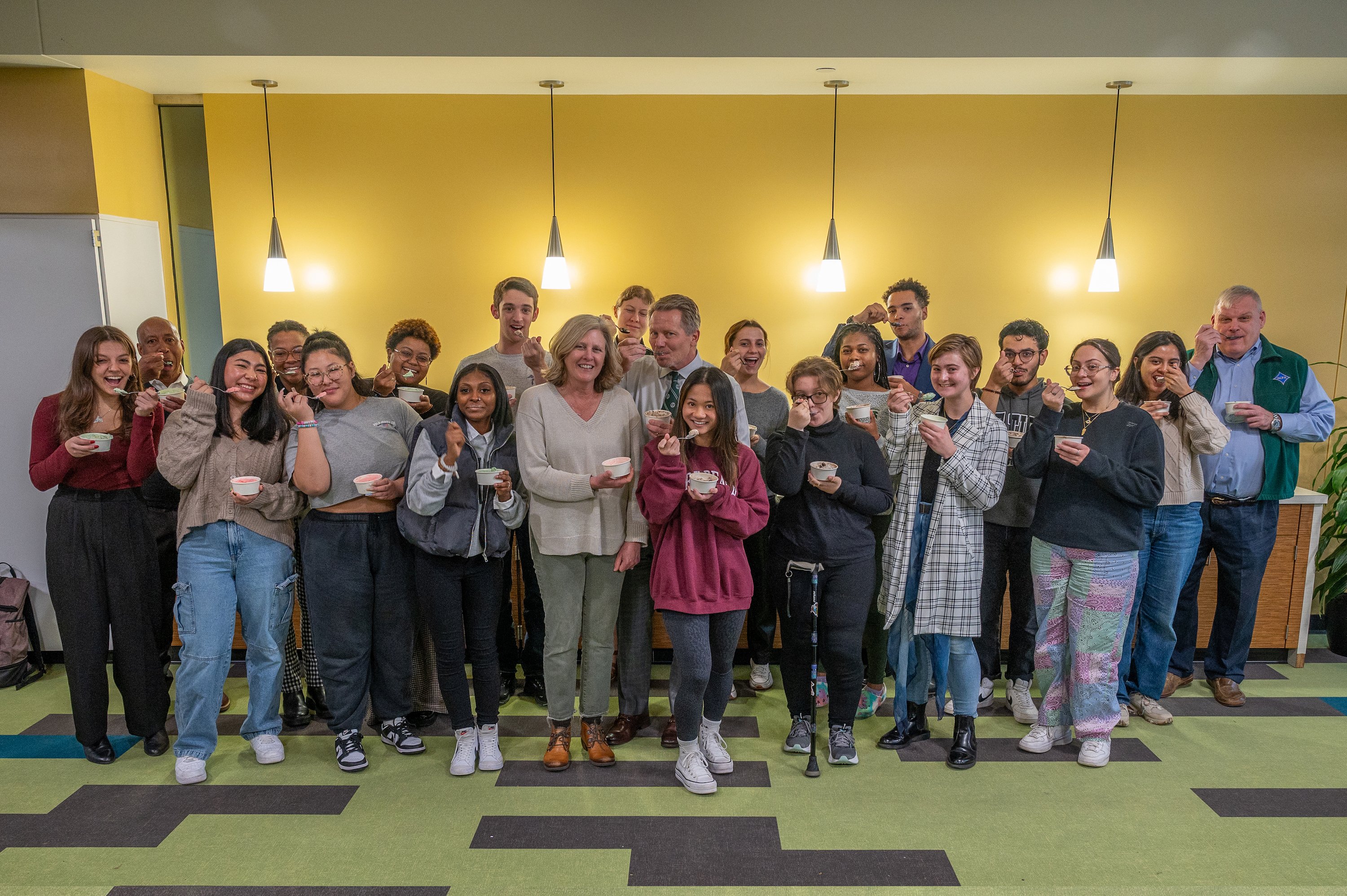 President-elect Kevin Guskiewicz poses with wife Amy, daughter Tessa and several other members of the MSU community while eating Dairy Store ice cream.