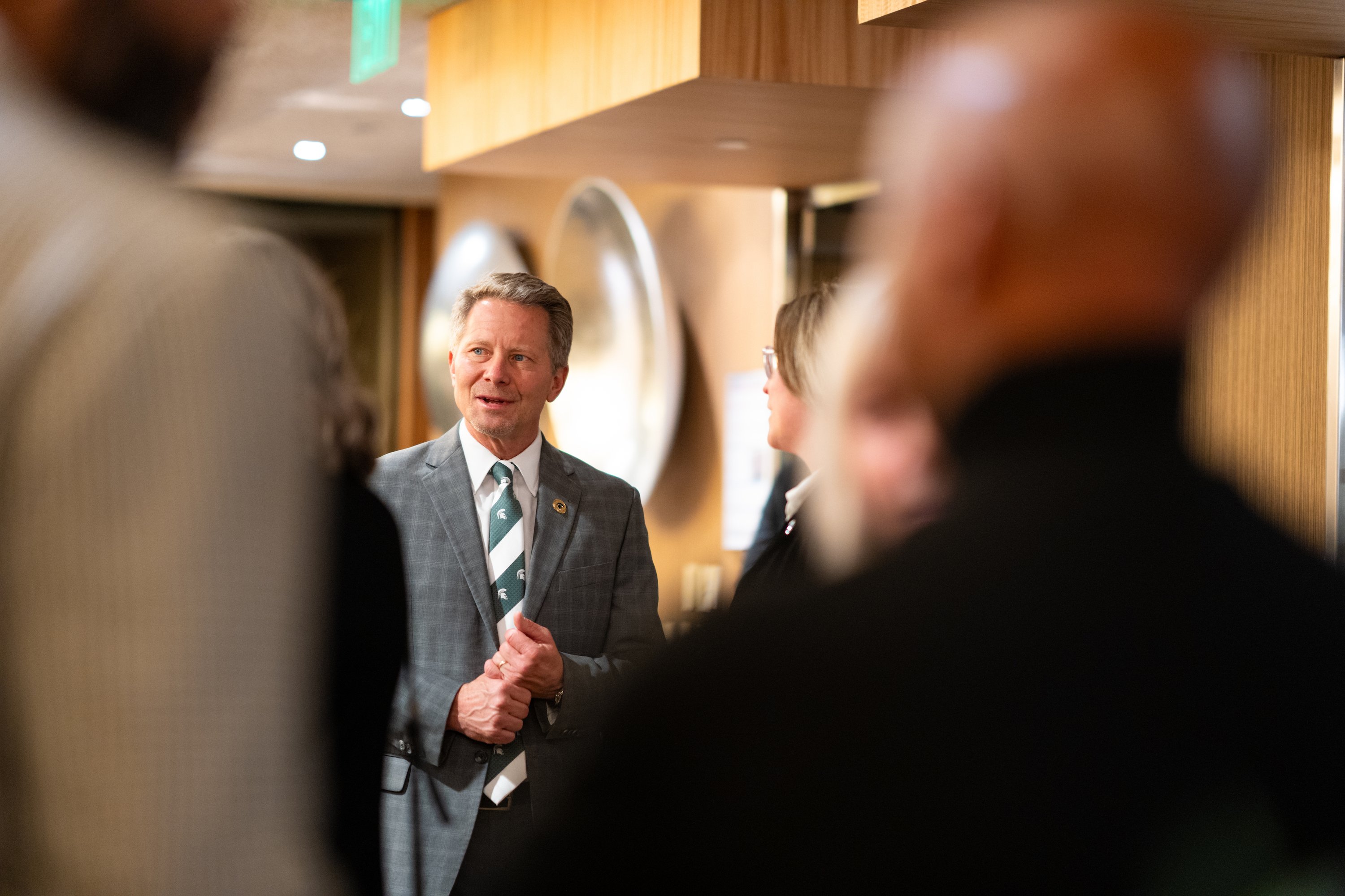President-elect Kevin Guskiewicz speaks with people at a meet and greet.