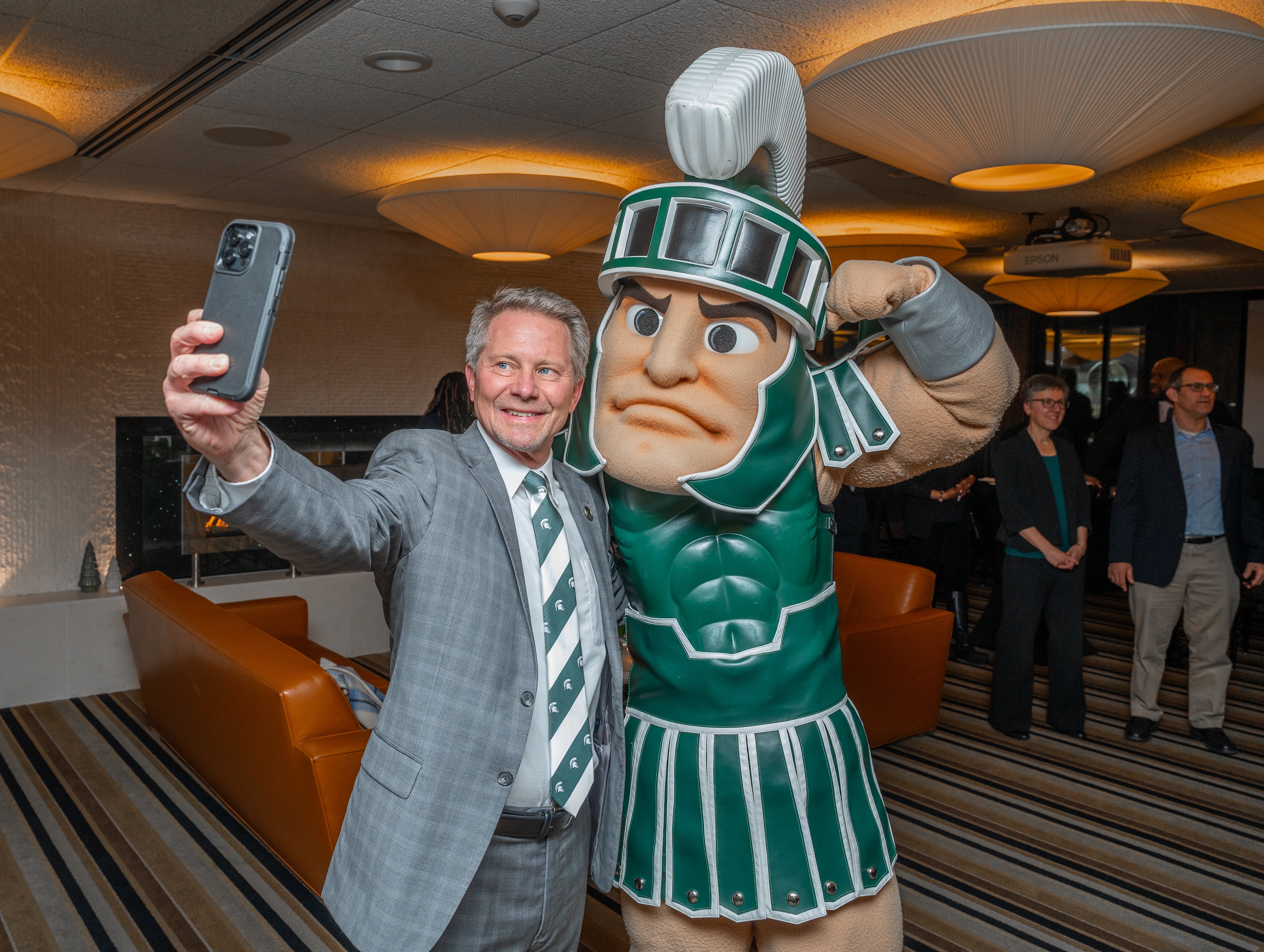 President-elect Kevin Guskiewicz takes a selfie with Sparty the mascot.