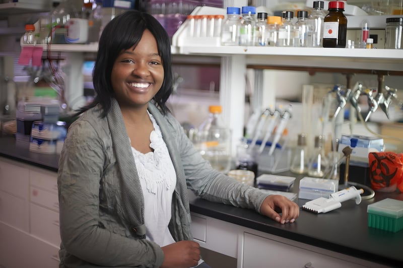 Woman posing by lab equipment 
