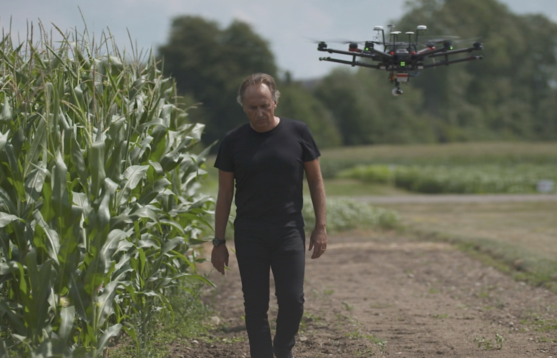Bruno Basso, John A. Hannah Distinguished Professor at Michigan State University, walks in front a drone in a field, which he uses to map Michigan farmers' fields and design a prescription for what their crops need.