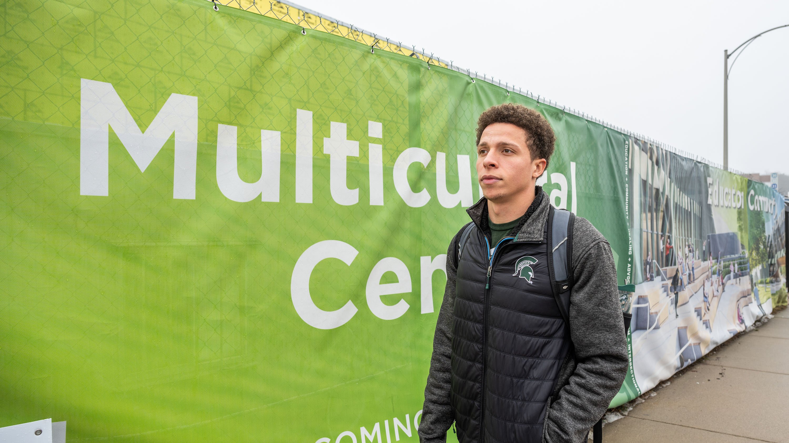 Student walking past multiculutral center construction site