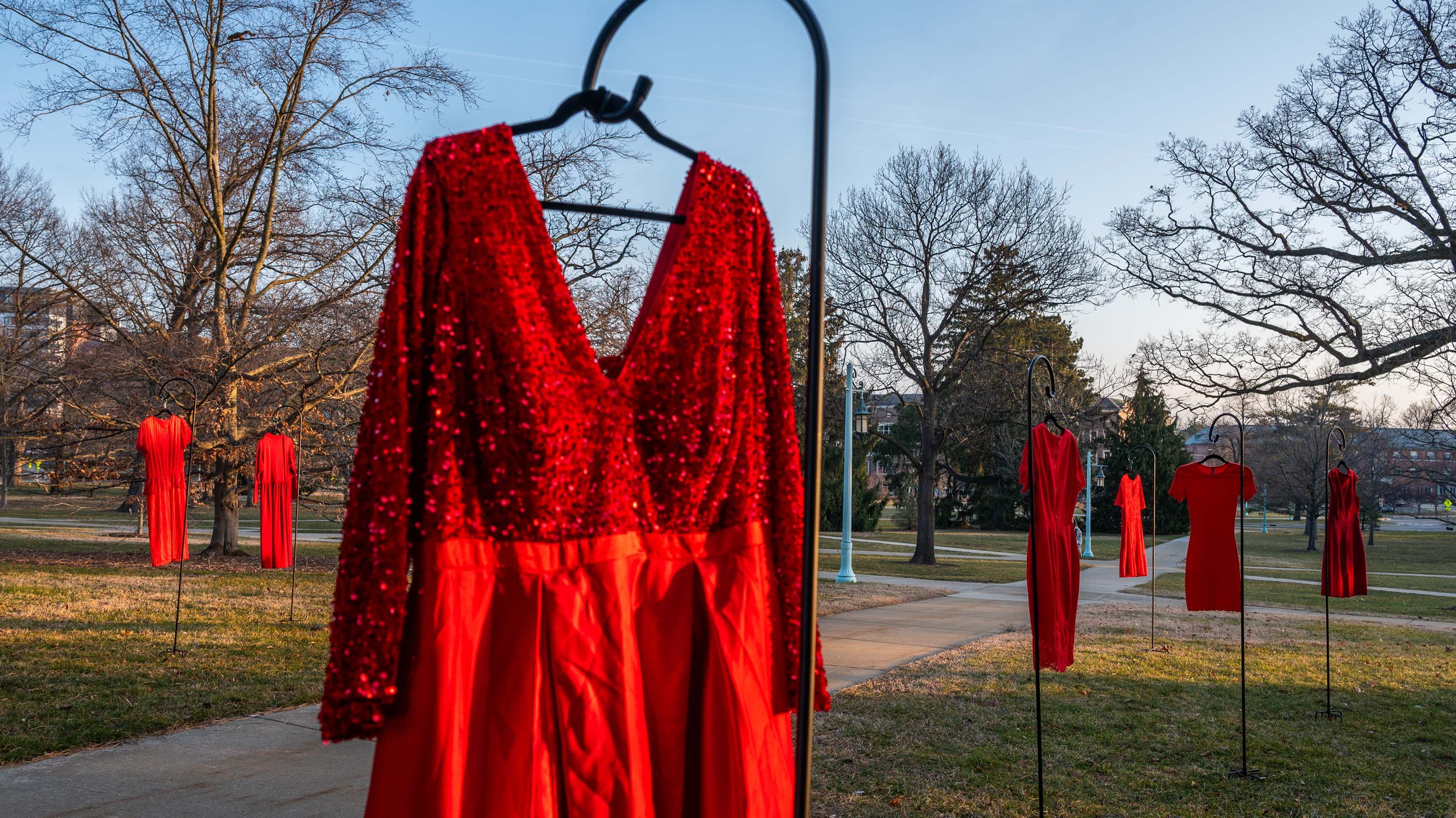Red dresses hanging on posts across campus